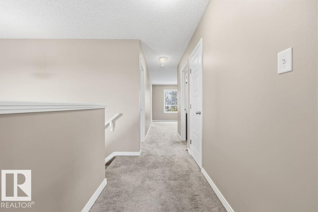 The property features a spacious room with light gray walls, gray carpeting, and white trim - 7873 170A Avenue, Edmonton, AB - Indoor Photo Showing Other Room