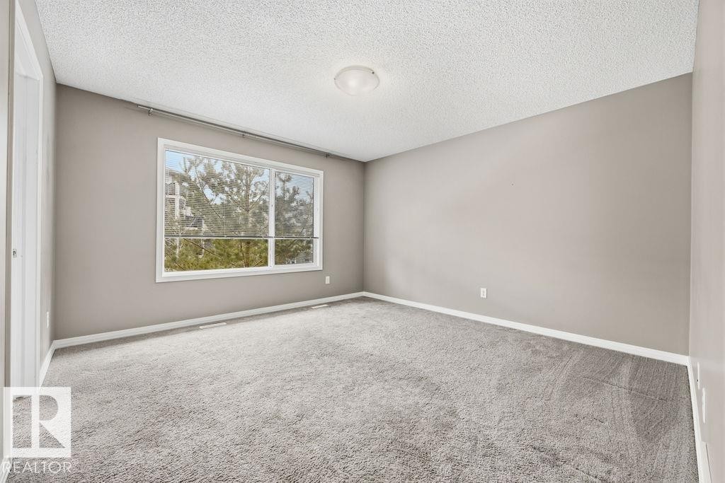 Room featuring neutral-toned walls, grey carpeting, and white trim - 7873 170A Avenue, Edmonton, AB - Indoor