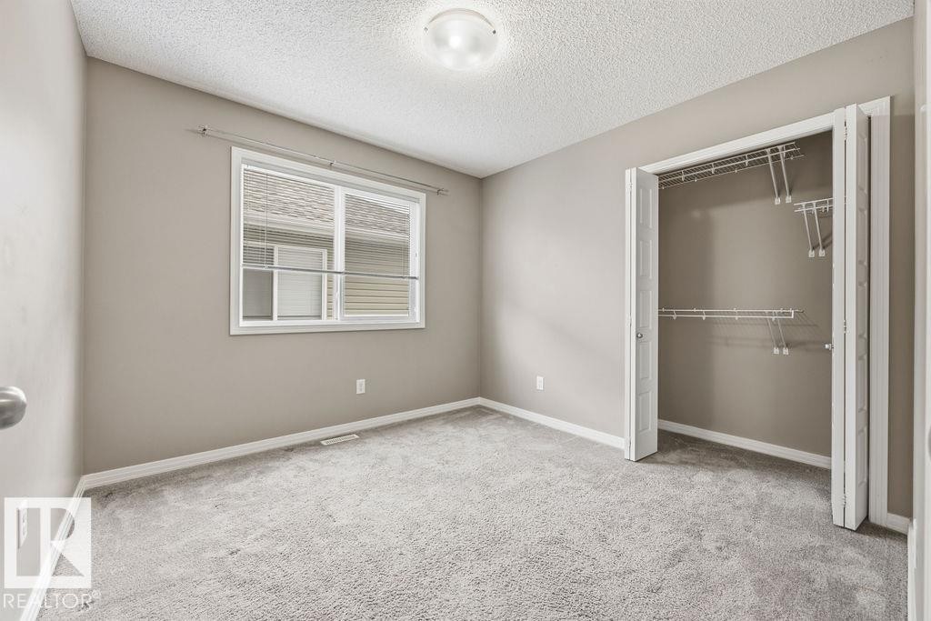Unfinished basement with exposed wooden beams, a painted concrete floor, and insulation along the perimeter walls - 7873 170A Avenue, Edmonton, AB - Indoor Photo Showing Basement