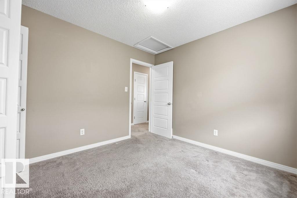 The property features a garage with a concrete floor, an overhead door, and exposed drywall - 7873 170A Avenue, Edmonton, AB - Indoor Photo Showing Garage