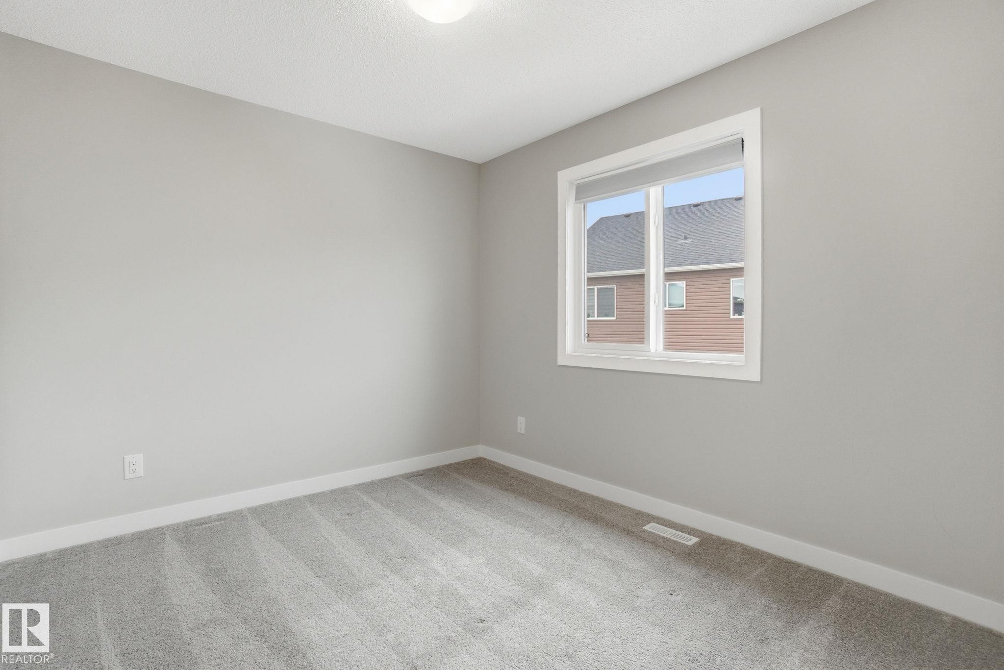 This room features light grey walls and light grey carpet - 1607 202 Street, Edmonton, AB - Indoor Photo Showing Other Room