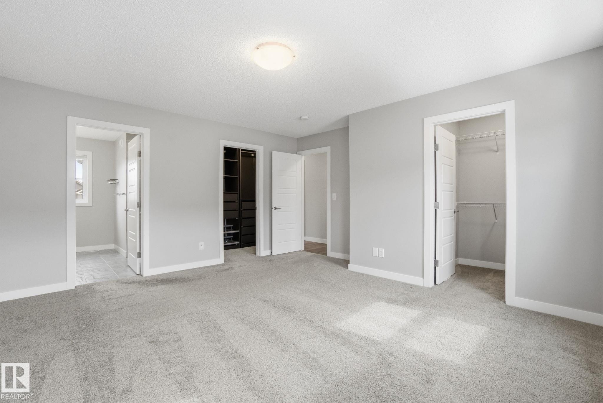 This room features light grey walls and light-colored carpet, creating a bright and airy atmosphere - 1607 202 Street, Edmonton, AB - Indoor
