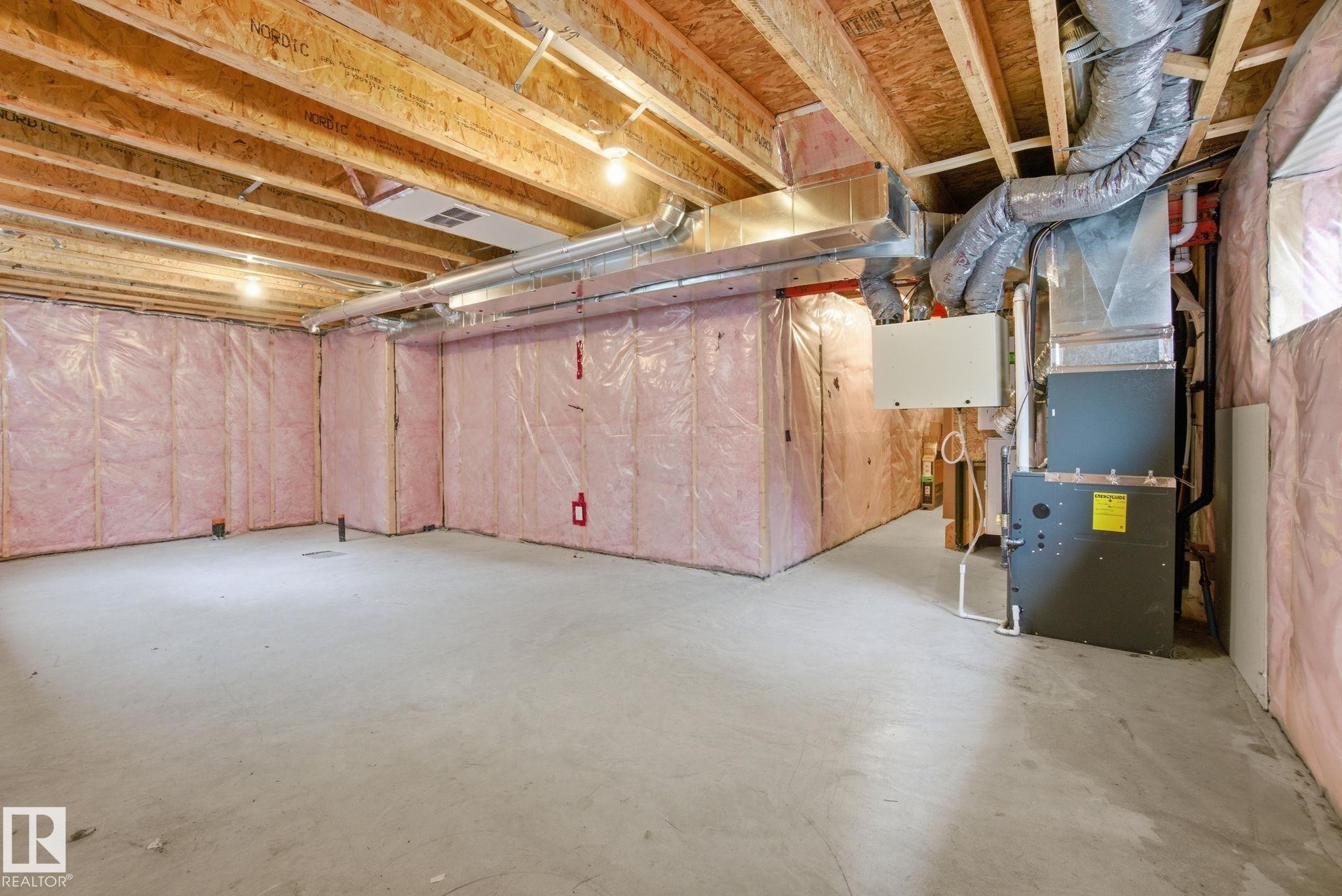 The property features a spacious unfinished basement with exposed wooden beams, concrete flooring, and insulated walls - 1607 202 Street, Edmonton, AB - Indoor Photo Showing Basement