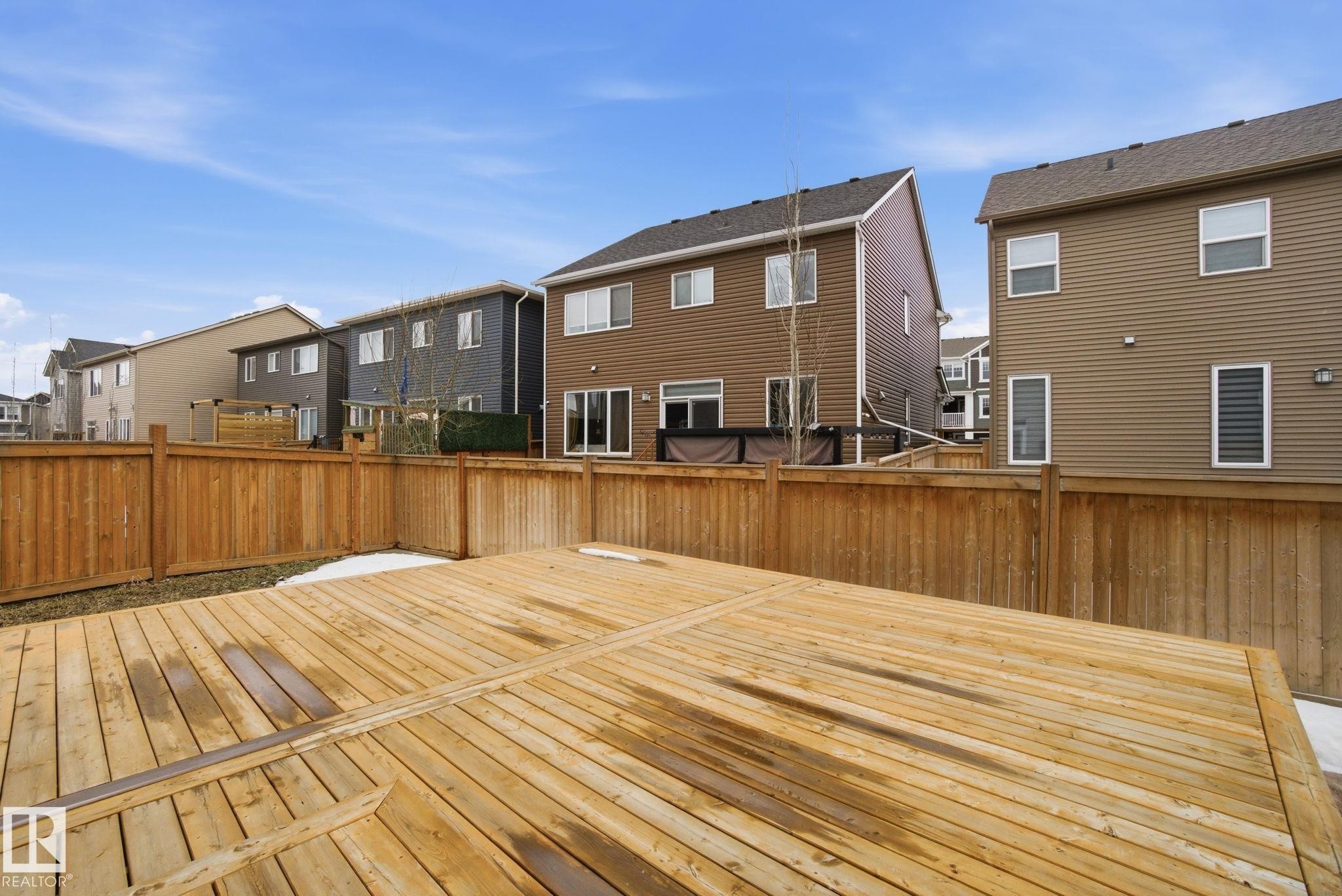 The property features a spacious wooden deck, enclosed by a wooden fence, providing a private outdoor space - 1607 202 Street, Edmonton, AB - Outdoor With Exterior