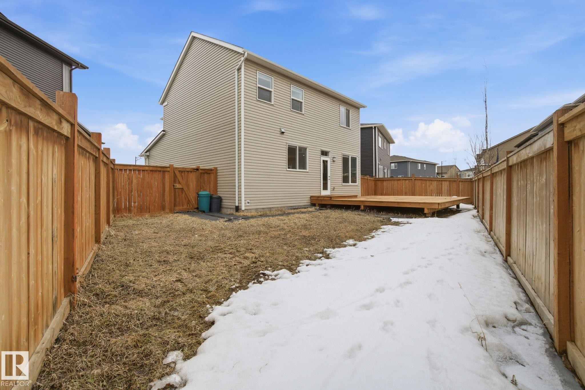 The property features a private yard with a wooden fence and a wooden deck - 1607 202 Street, Edmonton, AB - Outdoor With Exterior