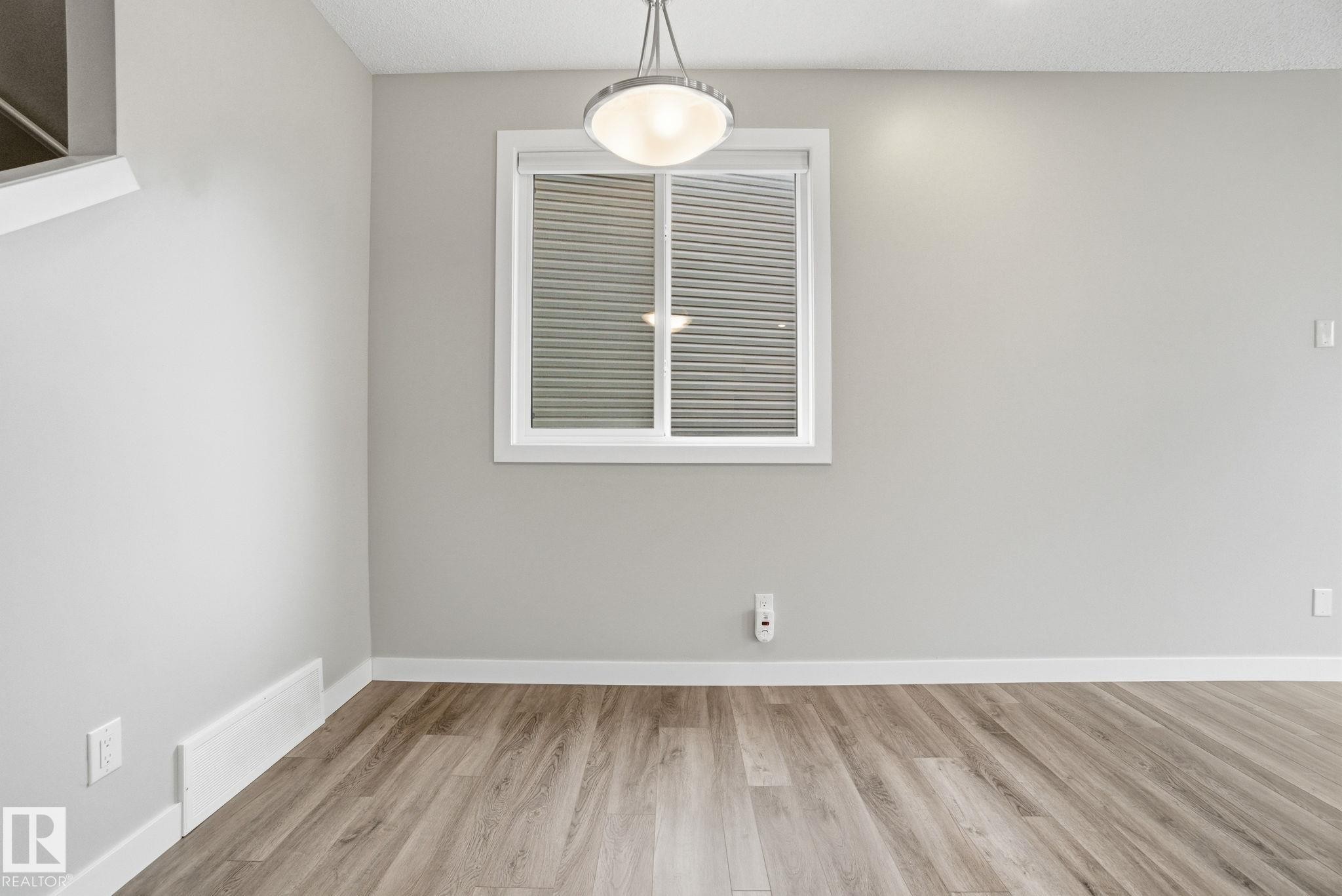 This room features light-colored walls and wood-look flooring - 1607 202 Street, Edmonton, AB - Indoor Photo Showing Other Room