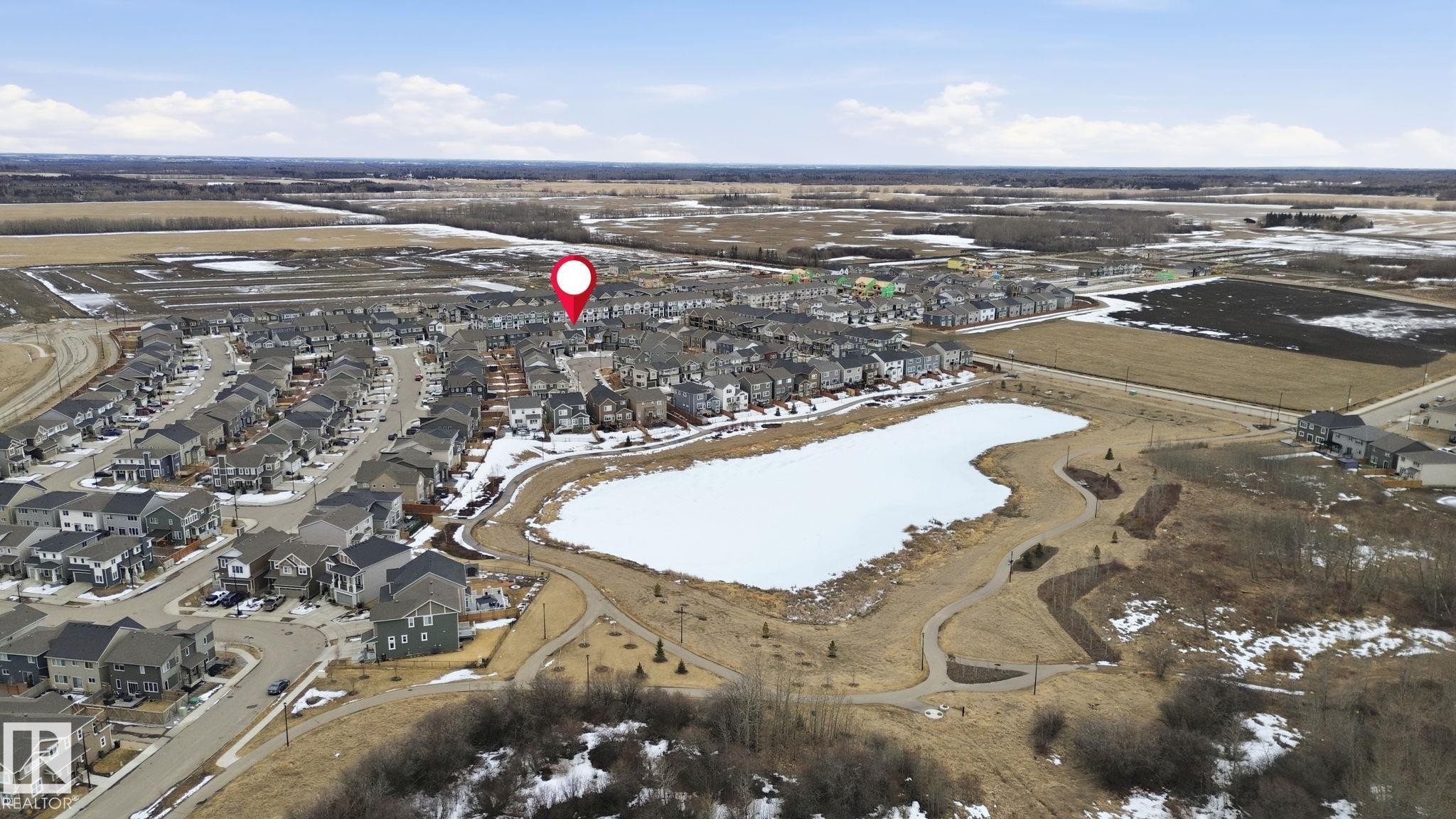 Aerial view of the community, featuring a frozen body of water and surrounding trails - 1607 202 Street, Edmonton, AB - Outdoor With View
