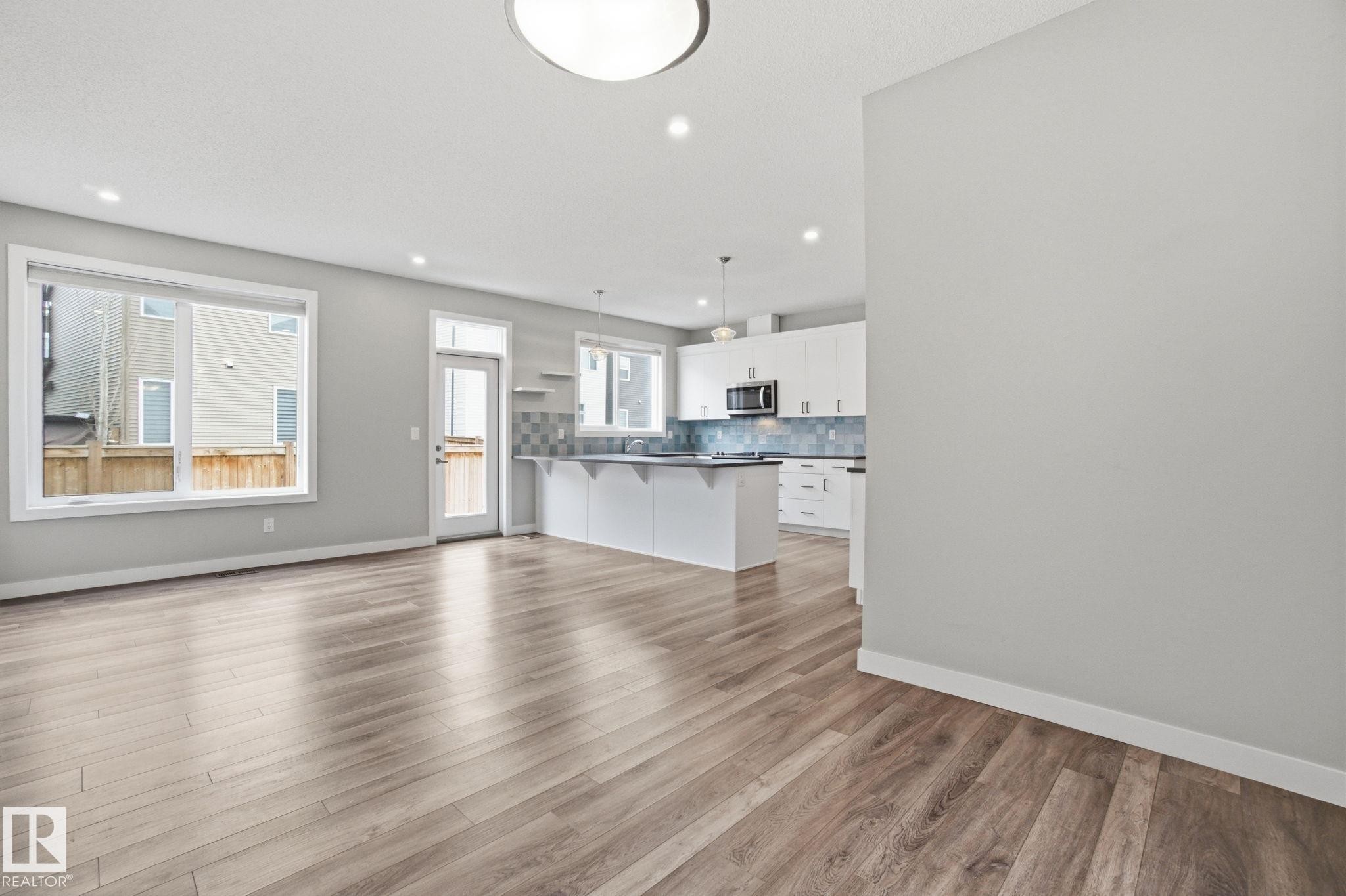 Open concept living space featuring wide plank flooring, recessed lighting, and large windows - 1607 202 Street, Edmonton, AB - Indoor