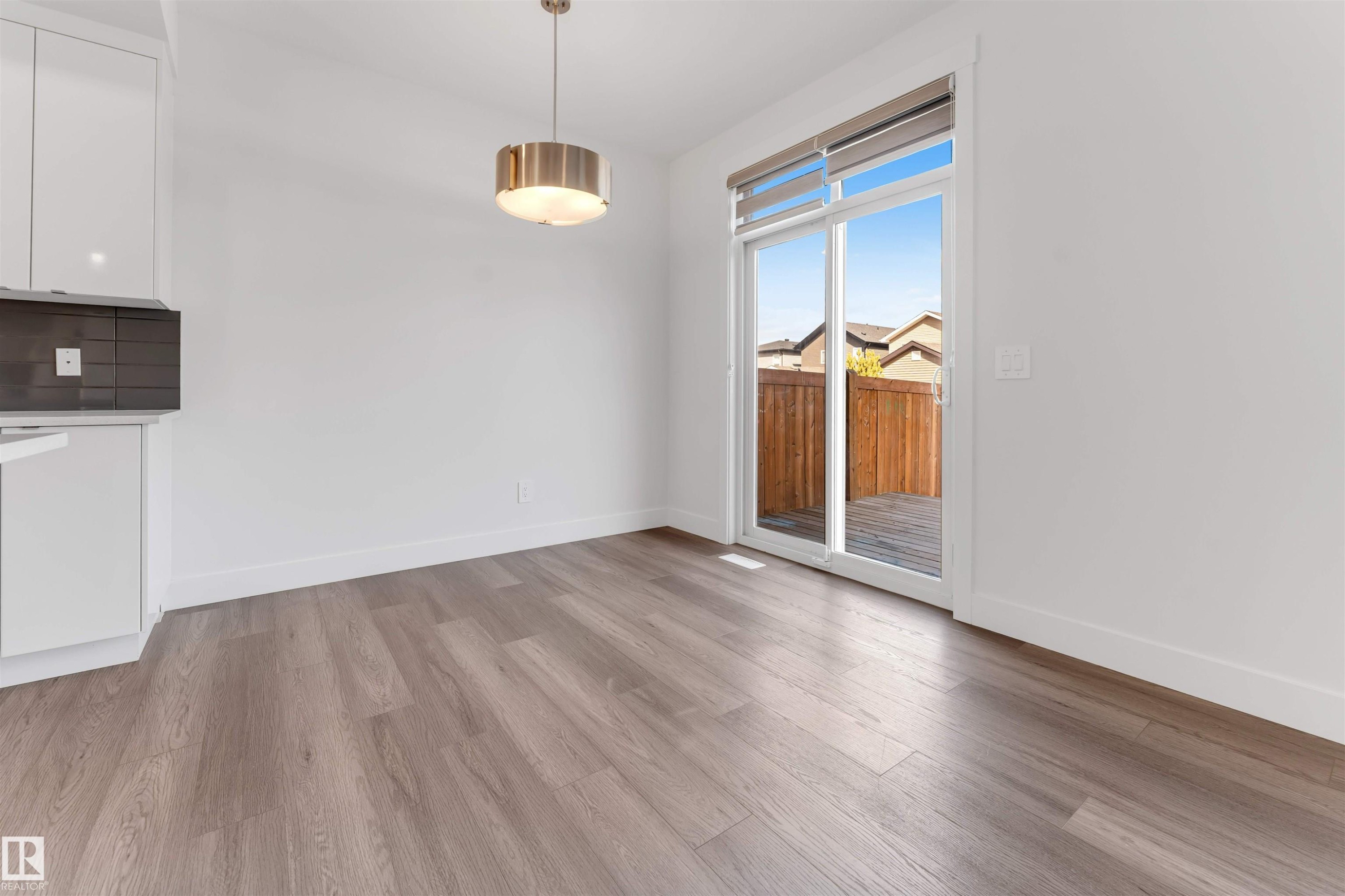 The property features light-toned flooring, white walls, and a modern ceiling light fixture - 1663 Cavanagh Boulevard Sw, Edmonton, AB - Indoor