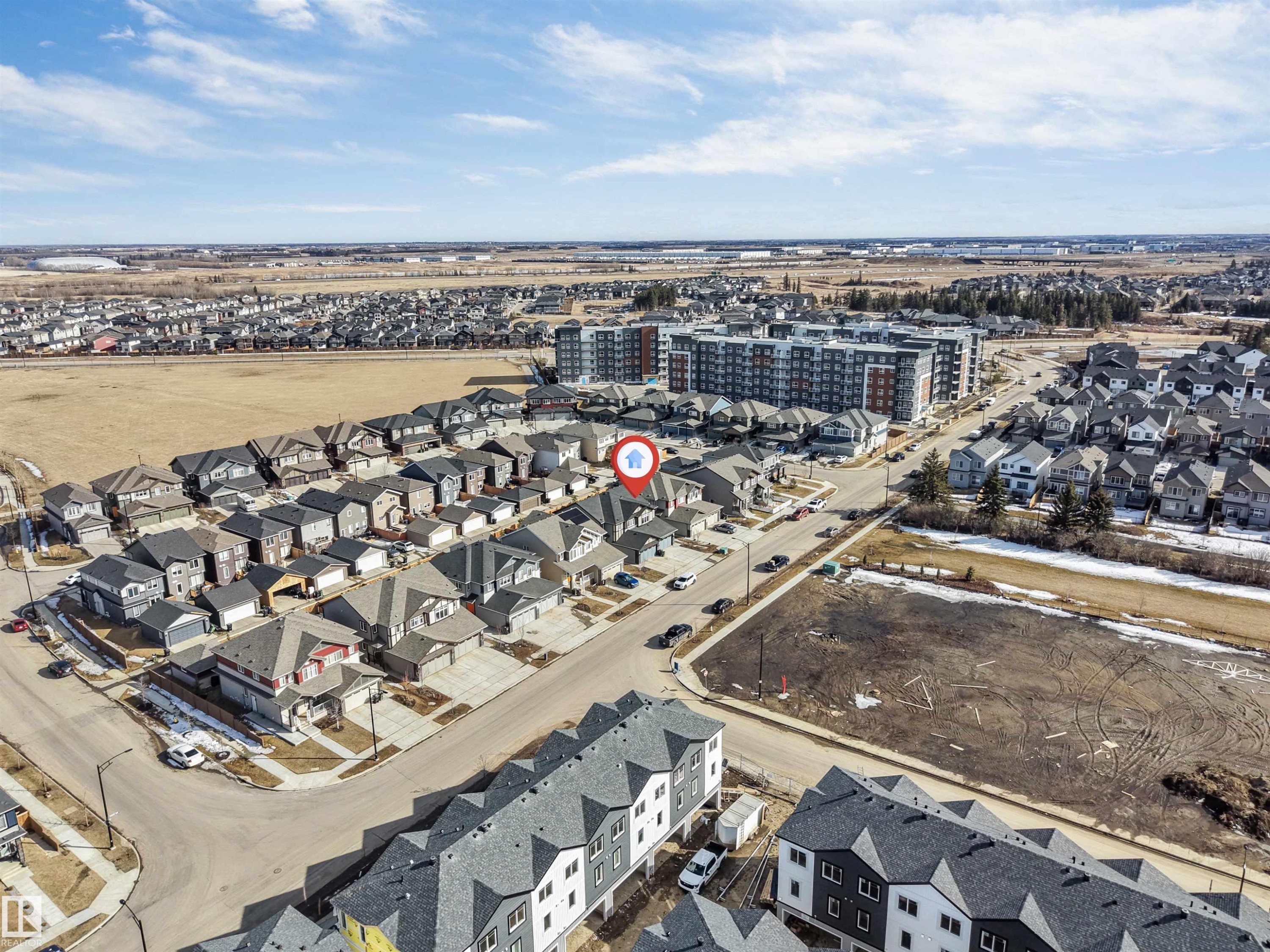 An aerial view of the property's neighborhood, showcasing residential streets, detached homes, and a larger apartment building in the surrounding area - 1663 Cavanagh Boulevard Sw, Edmonton, AB - Outdoor With View