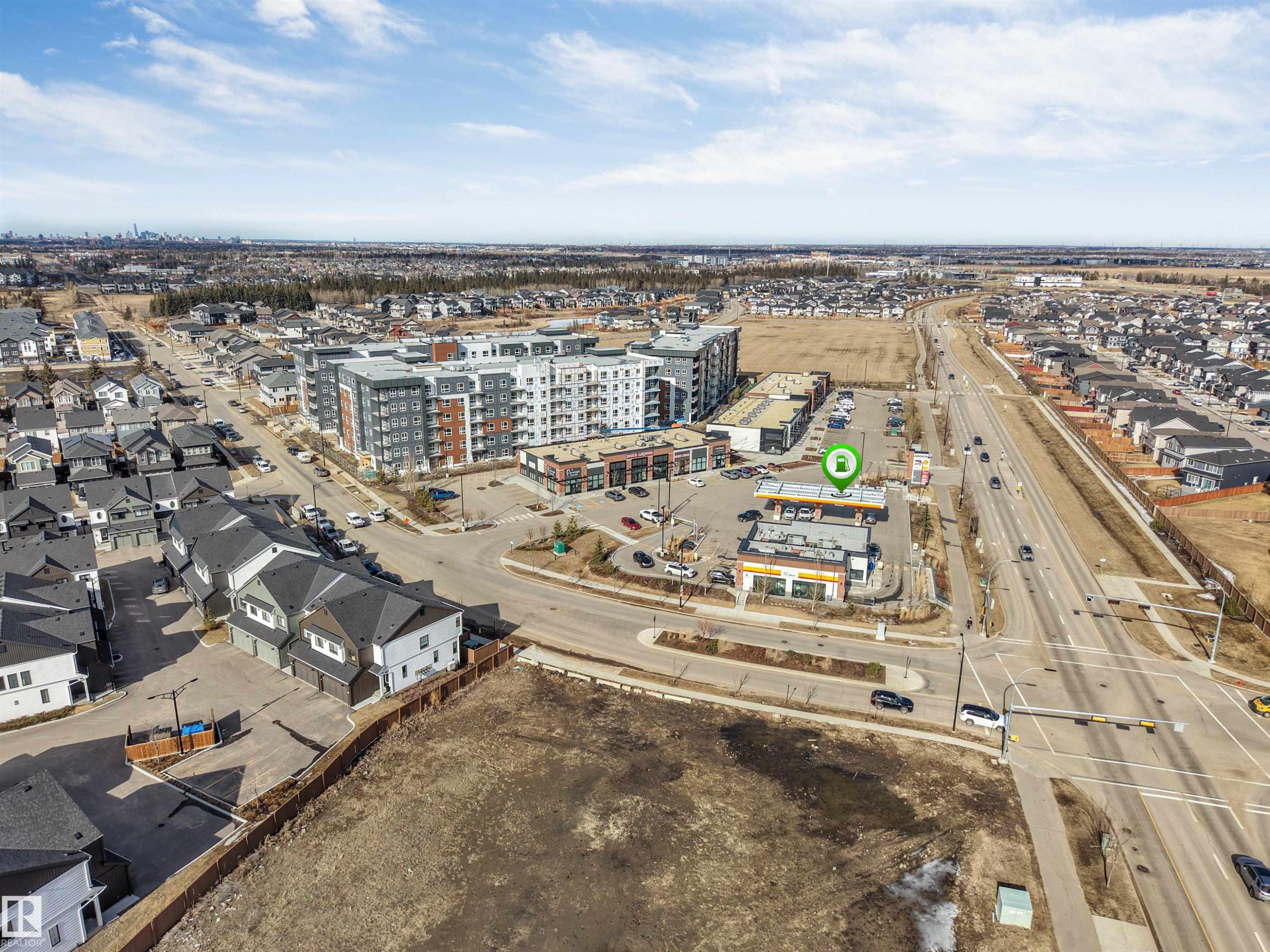Aerial view showcasing a developed neighborhood with residential properties, commercial buildings, and a major roadway - 1663 Cavanagh Boulevard Sw, Edmonton, AB - Outdoor With View