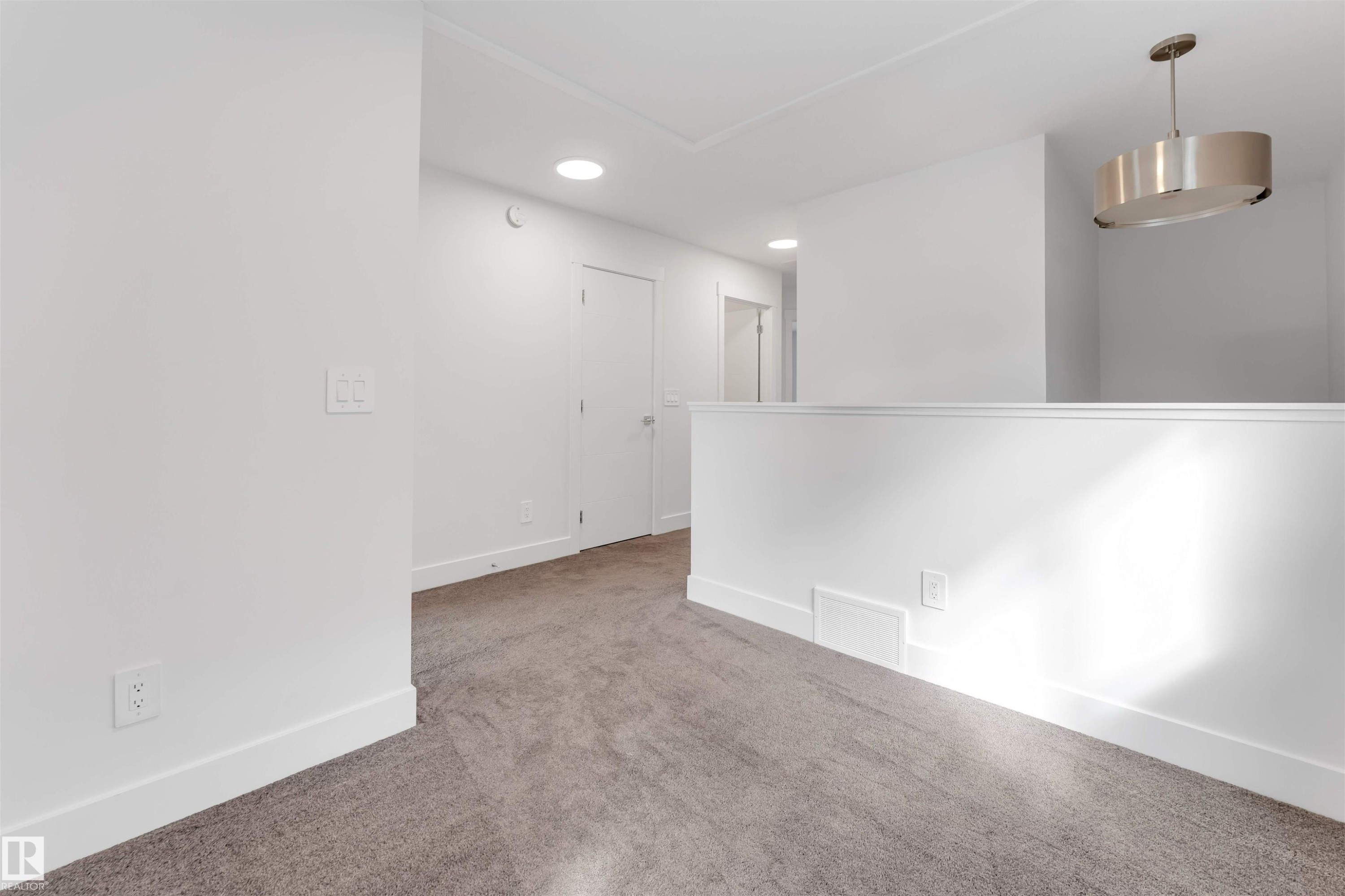 This area features neutral tone carpet, white walls, and recessed lighting - 1663 Cavanagh Boulevard Sw, Edmonton, AB - Indoor Photo Showing Other Room