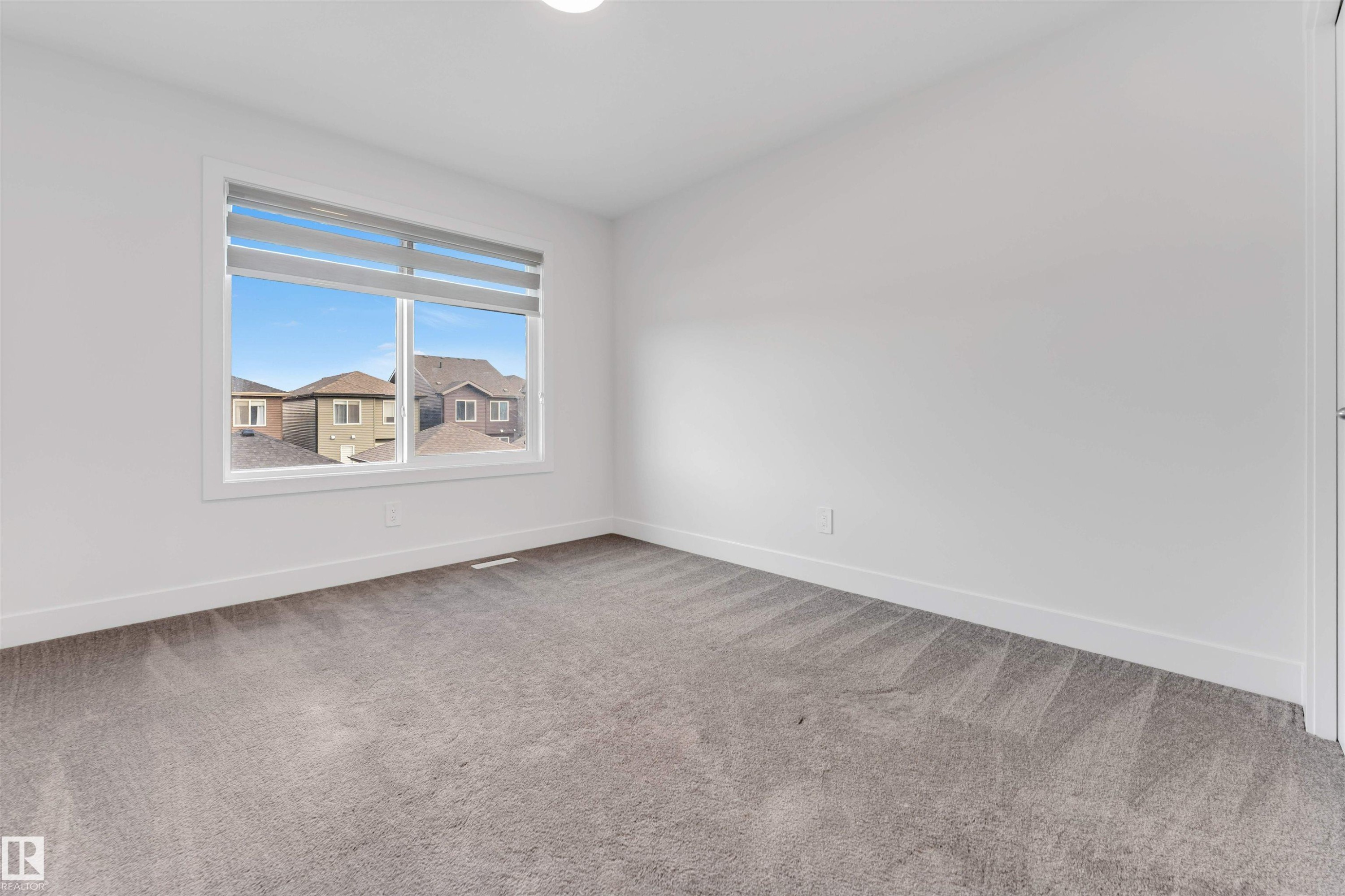 This room features a window with blinds, carpeted flooring, and white walls - 1663 Cavanagh Boulevard Sw, Edmonton, AB - Indoor Photo Showing Other Room