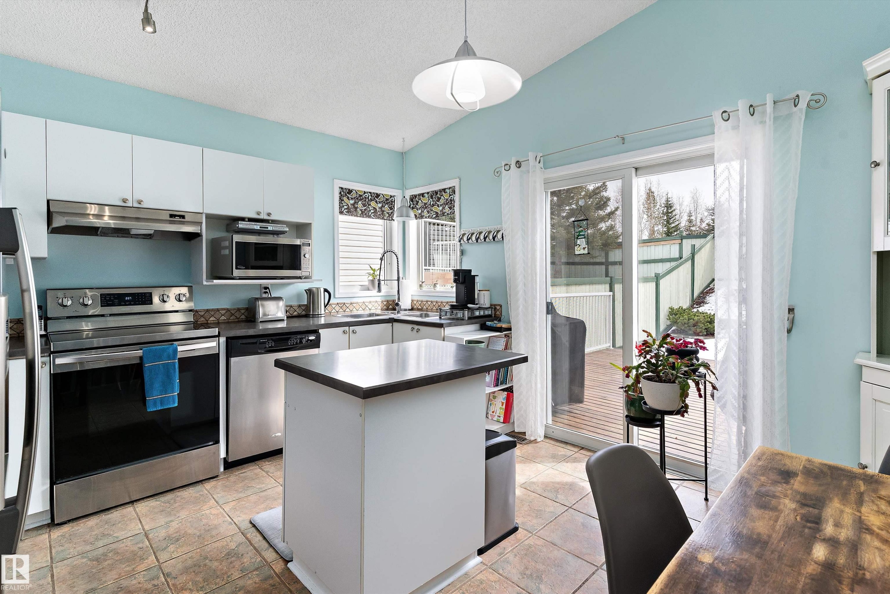 The kitchen features white cabinetry, stainless steel appliances, and a central island - 322 Pearson Crescent, Edmonton, AB - Indoor Photo Showing Kitchen