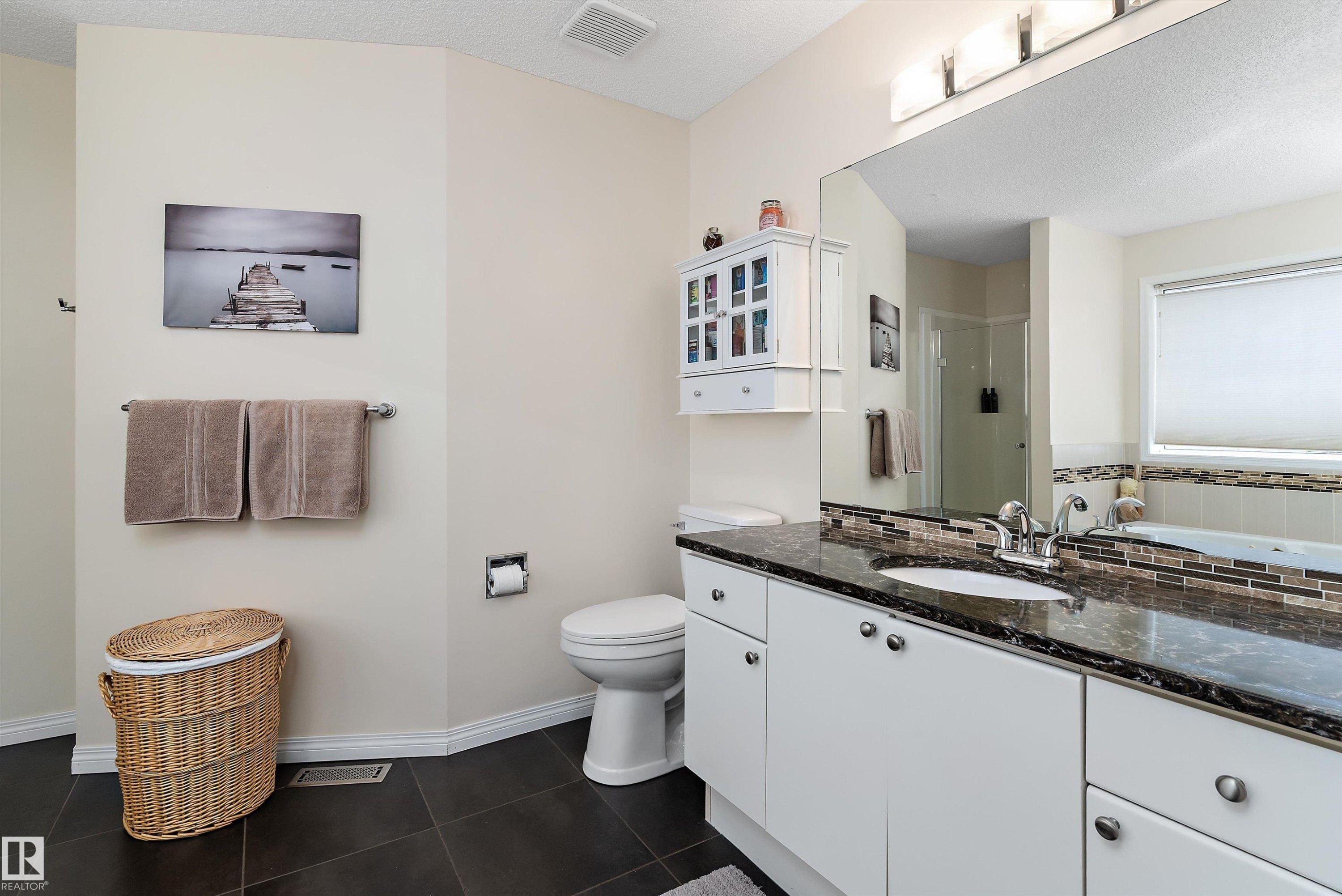 Bathroom featuring a white vanity with a dark countertop and a large mirror - 322 Pearson Crescent, Edmonton, AB - Indoor Photo Showing Bathroom