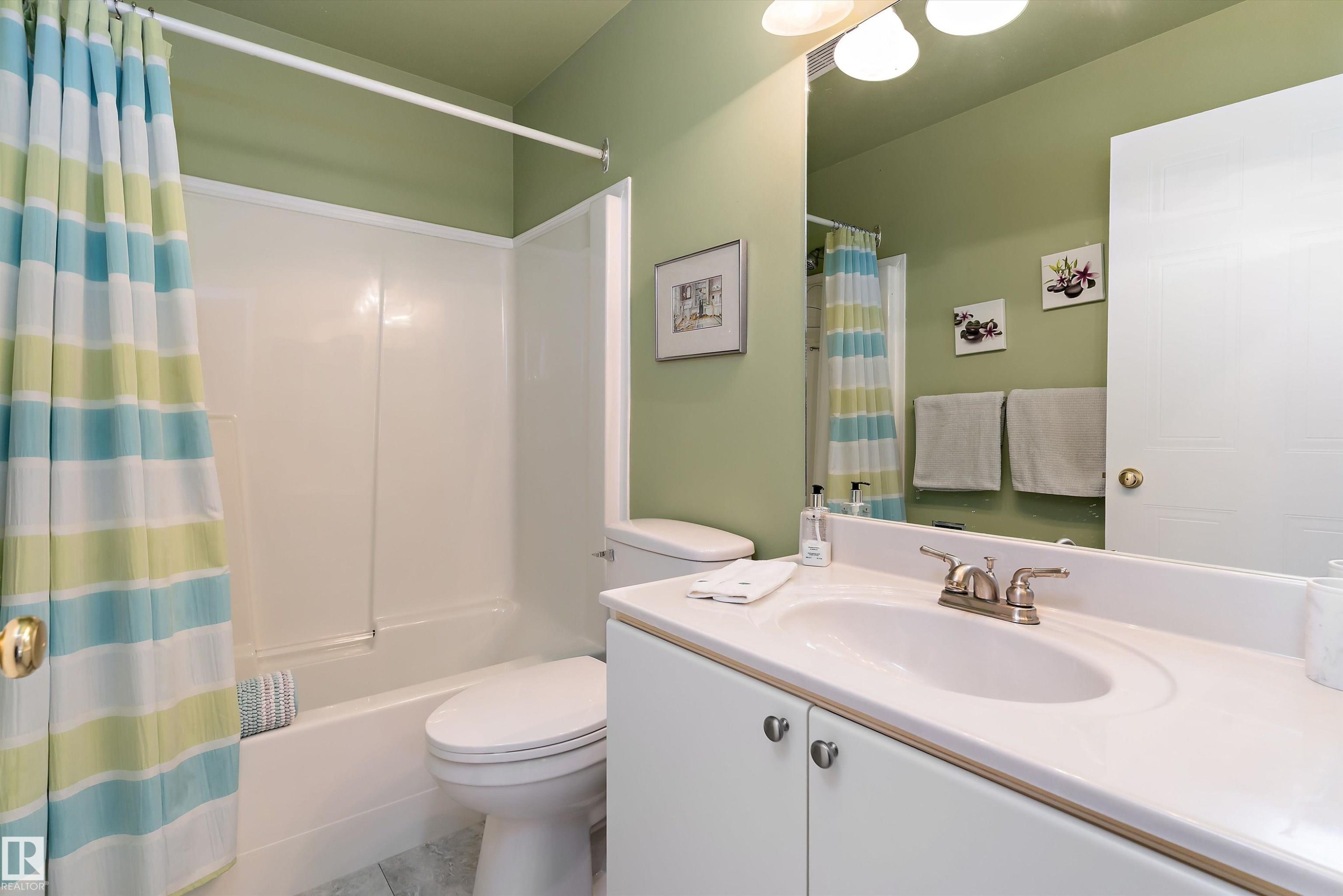 This bathroom features a white vanity with a single sink and brushed nickel faucet, a toilet, and a bathtub with an integrated shower - 322 Pearson Crescent, Edmonton, AB - Indoor Photo Showing Bathroom