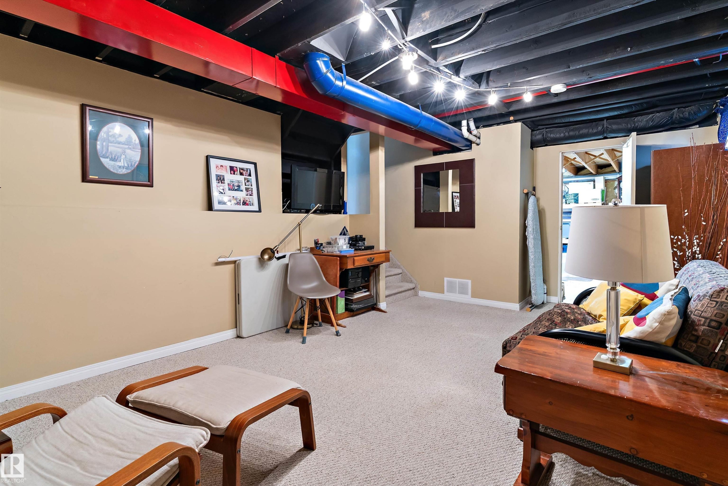 This versatile space features carpeting, light-colored walls, and exposed ceiling joists with lighting fixtures - 322 Pearson Crescent, Edmonton, AB - Indoor Photo Showing Basement