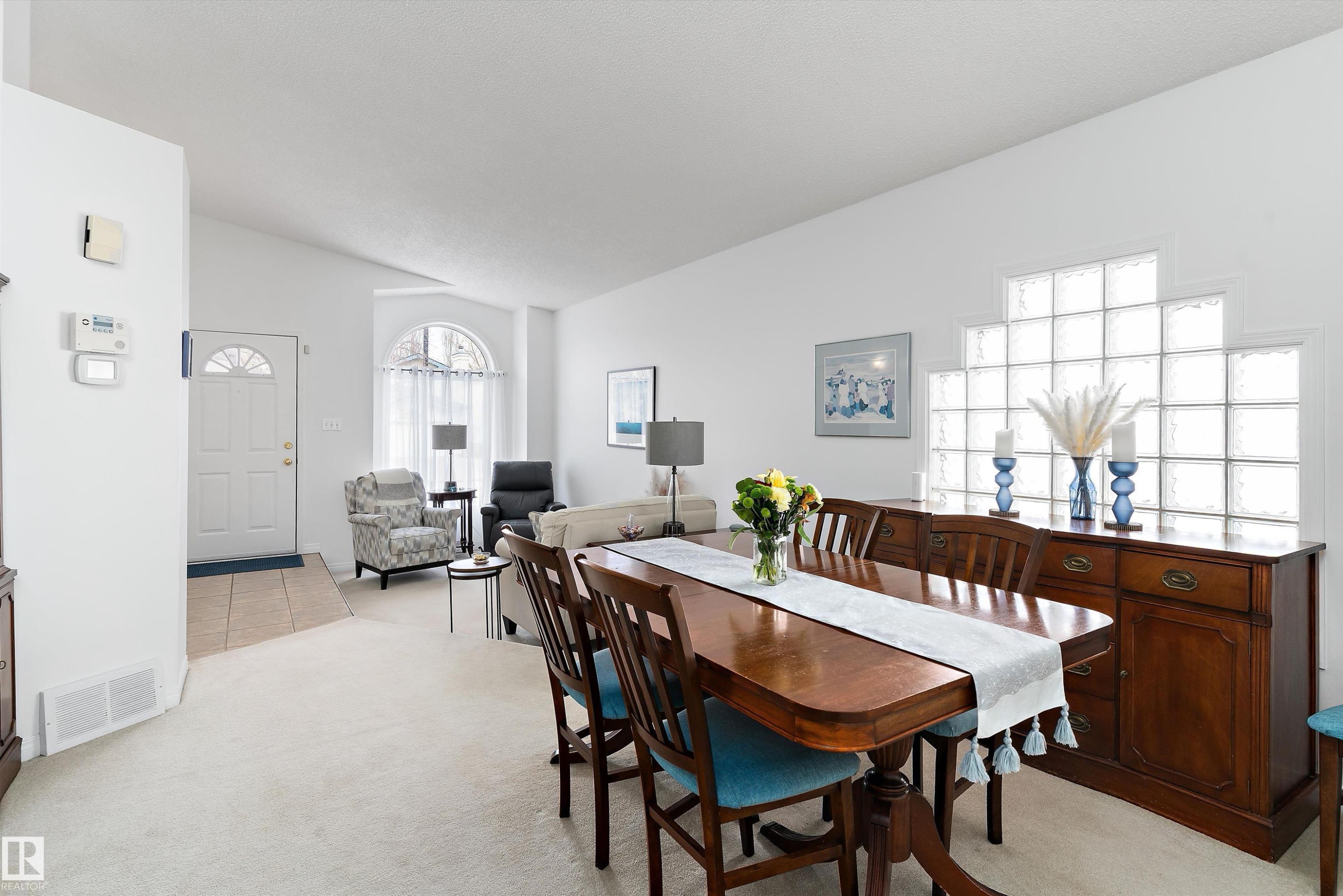 This inviting interior features a dining area with a wooden table and chairs, complemented by a matching wooden sideboard - 322 Pearson Crescent, Edmonton, AB - Indoor Photo Showing Dining Room
