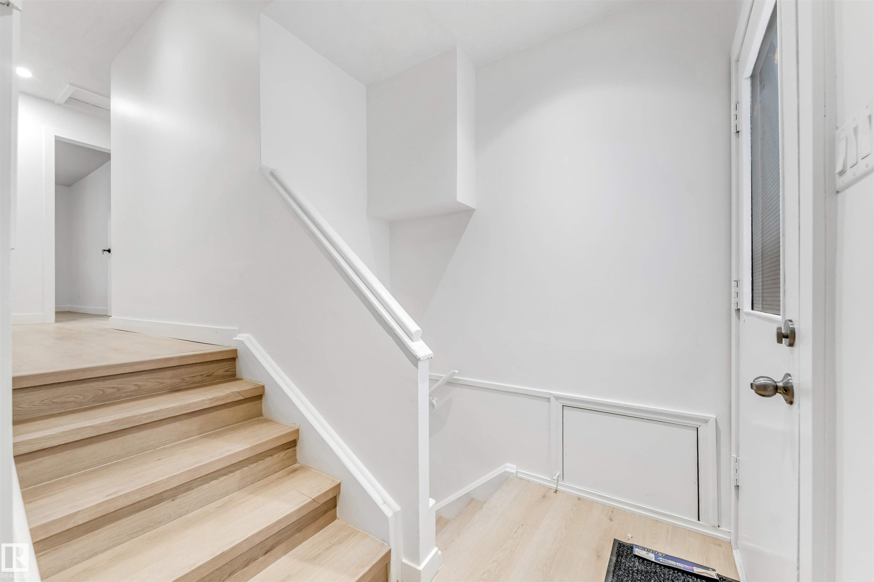 Staircase with light wood treads and white risers, featuring a white railing and light wood flooring - 12423 91 Street, Edmonton, AB - Indoor Photo Showing Other Room