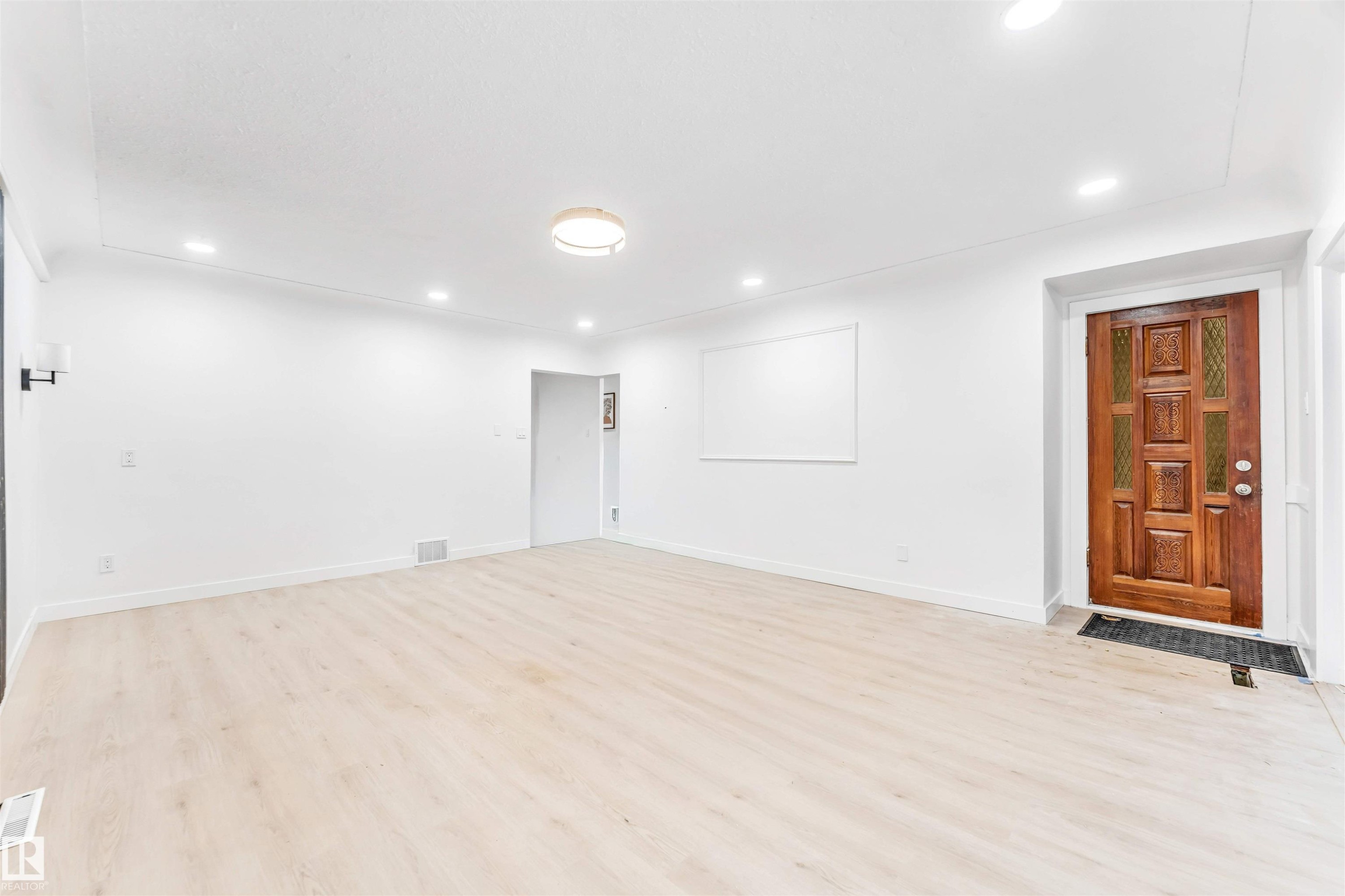 The property features an entryway with a detailed wooden door, light-colored flooring, and recessed lighting throughout the space - 12423 91 Street, Edmonton, AB - Indoor
