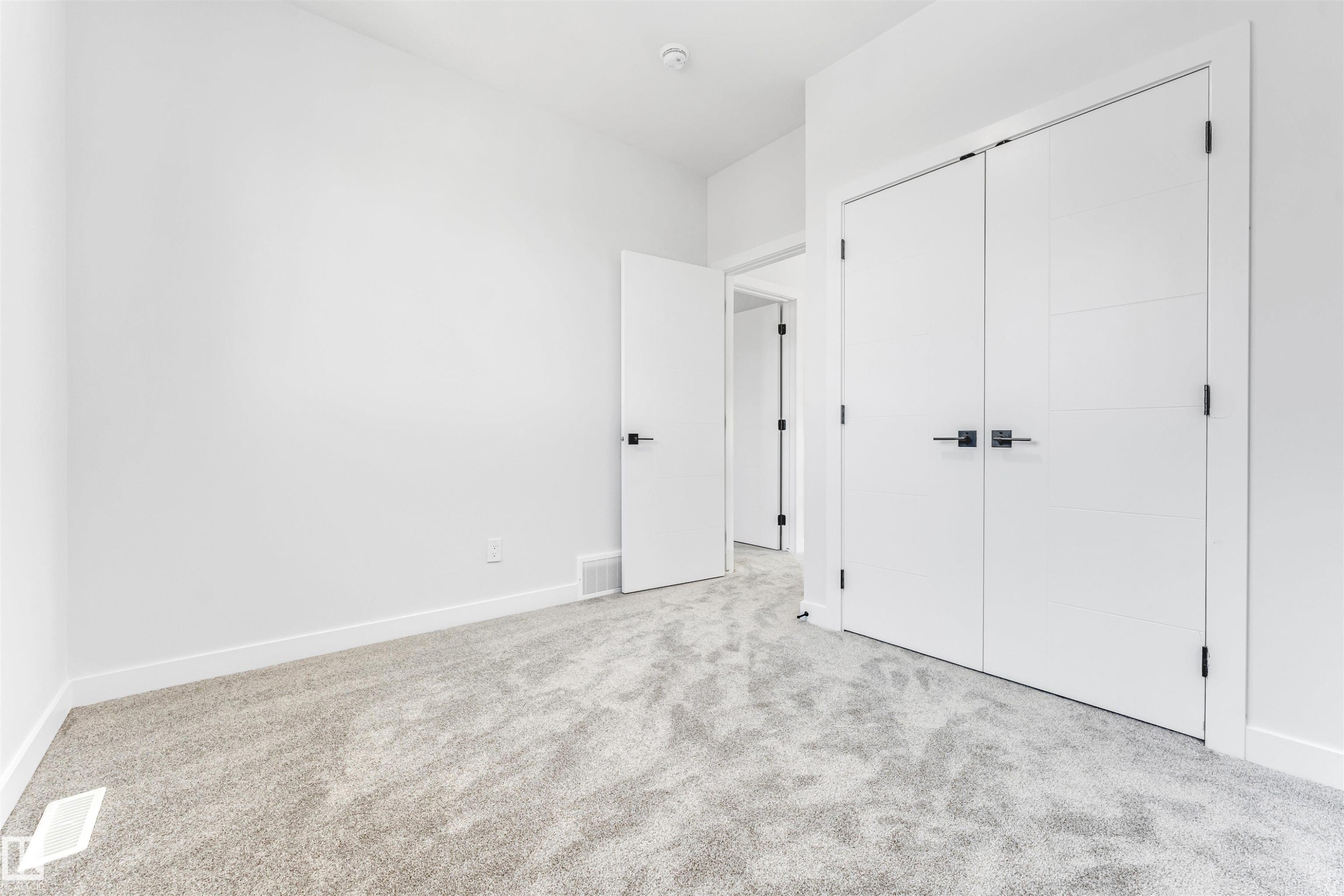 This room features a soft, grey carpet and clean white walls, creating a neutral canvas - 10962 157 Street, Edmonton, AB - Indoor Photo Showing Other Room