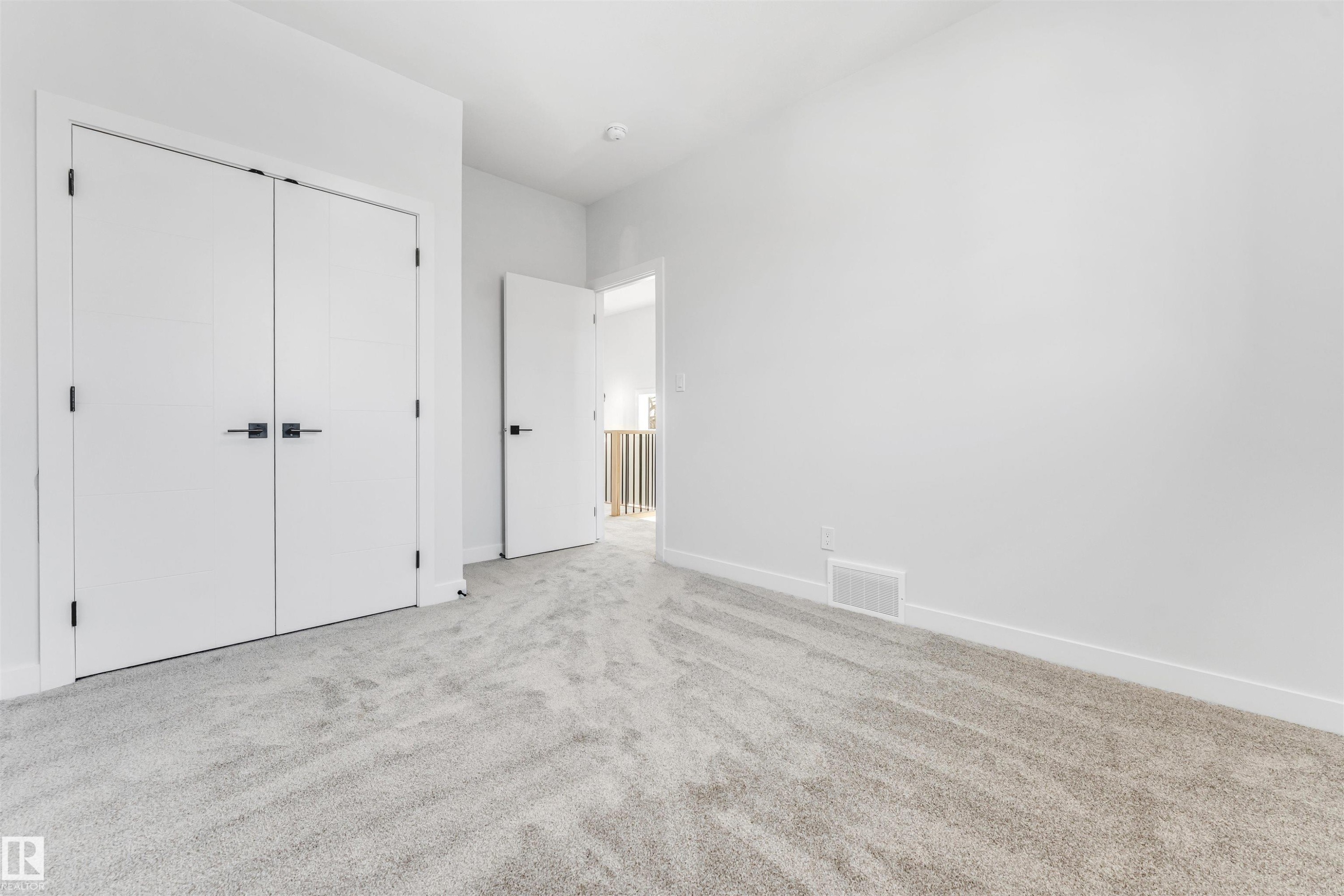 This room features a neutral color palette with light-colored carpeting and white walls - 10962 157 Street, Edmonton, AB - Indoor Photo Showing Other Room