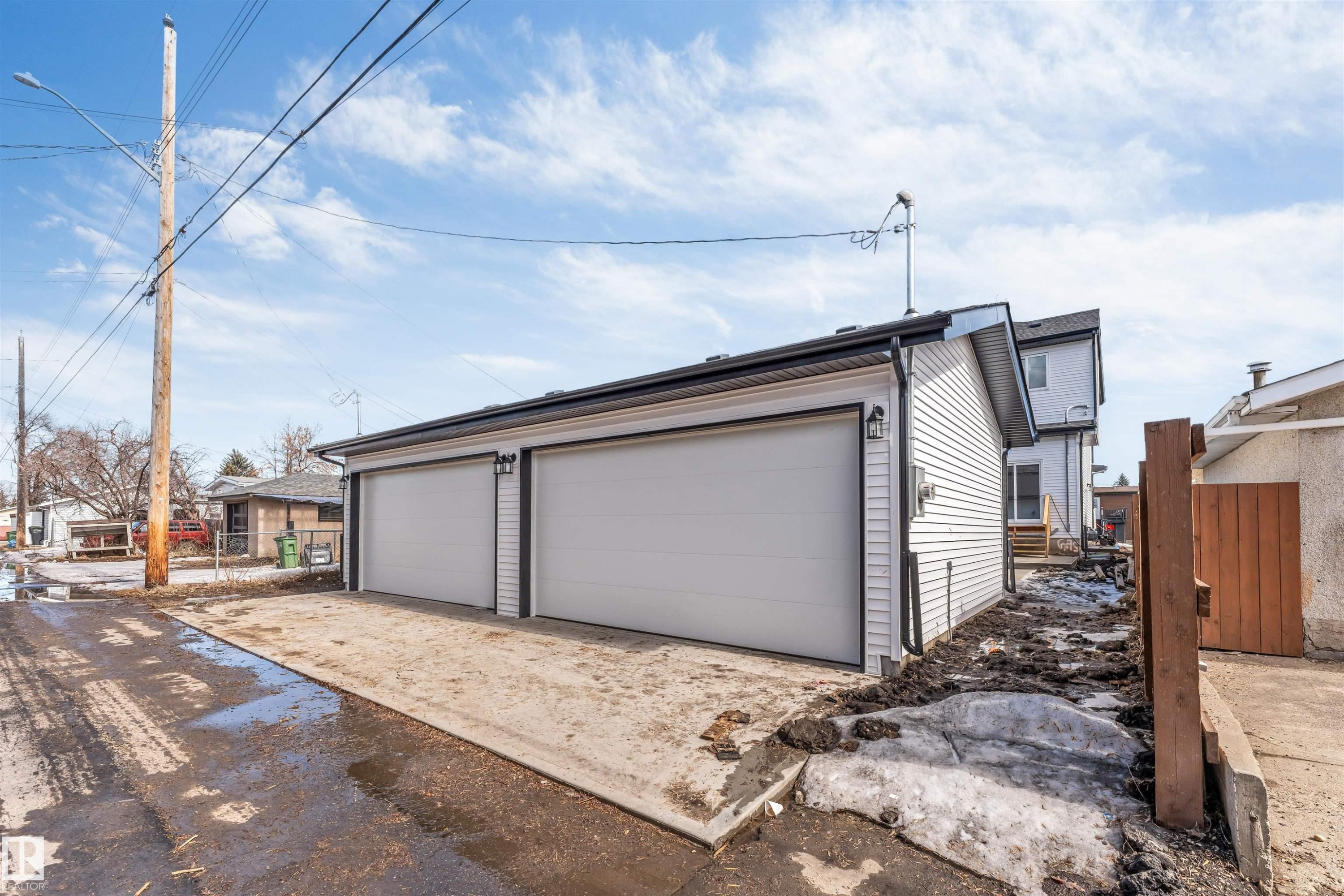 The property features a detached garage with two garage doors and an exterior finished with white siding - 10962 157 Street, Edmonton, AB - Outdoor With Exterior