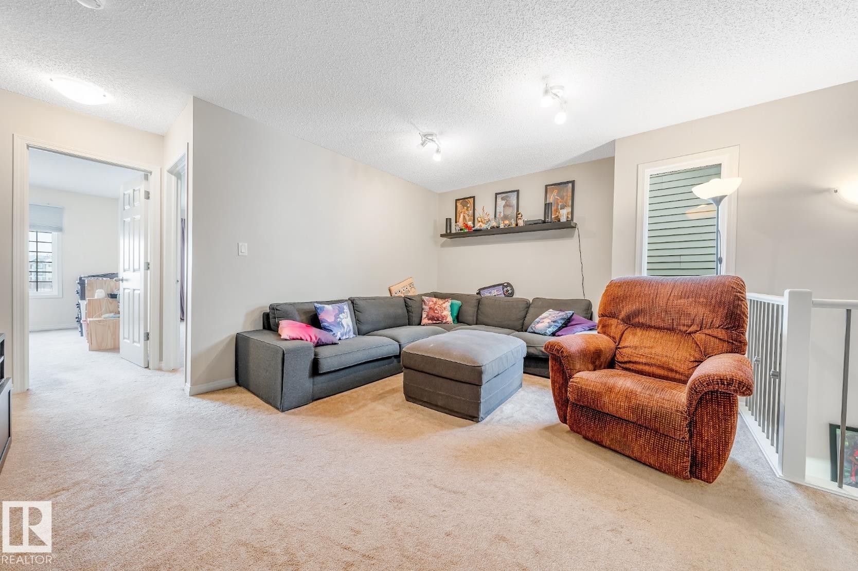 This property features light-colored carpeting, white baseboards, and neutral-toned walls throughout - 3109 Carpenter Landing, Edmonton, AB - Indoor Photo Showing Living Room