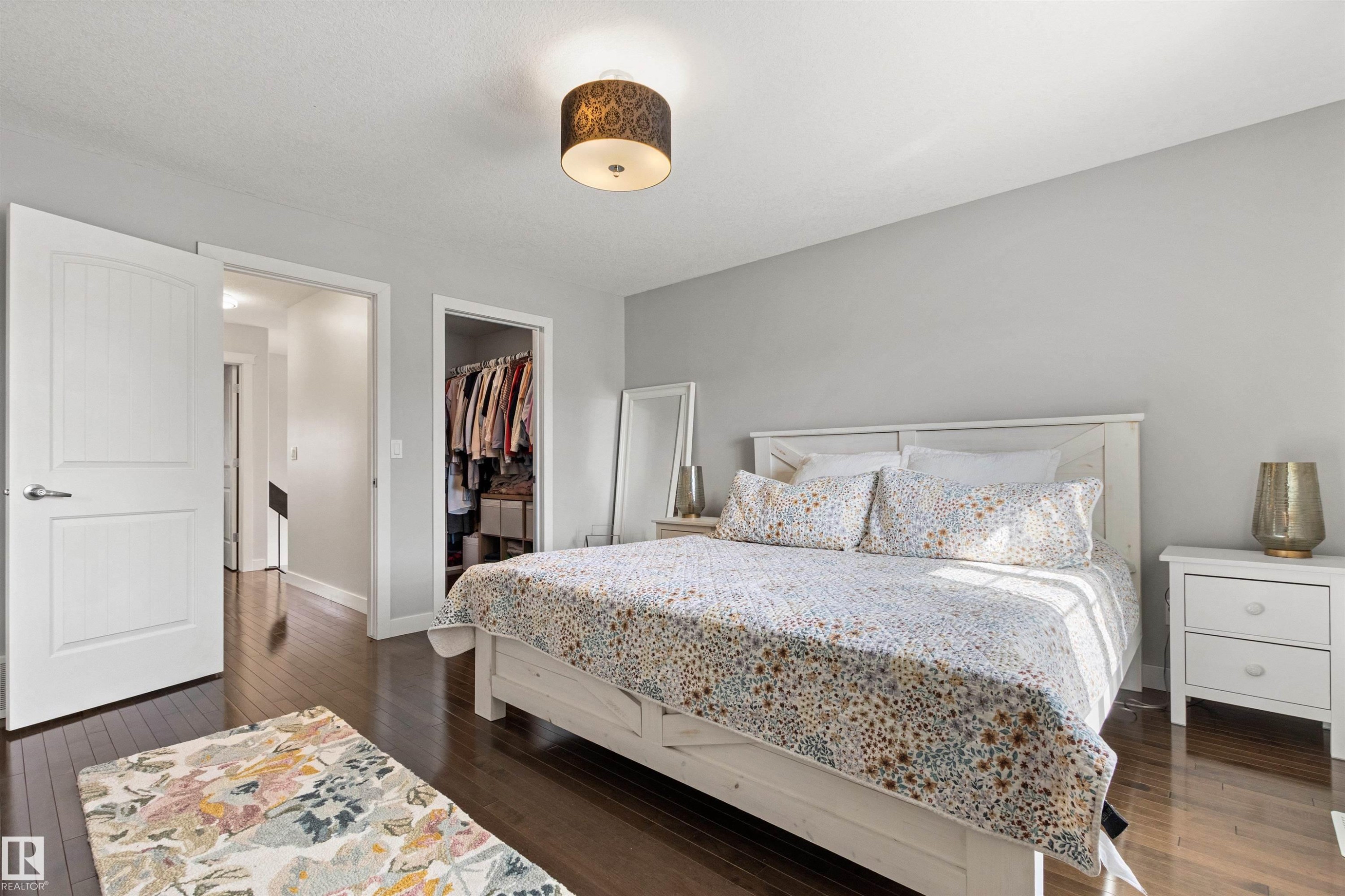 This bedroom features dark hardwood floors and light gray walls - 38 Hewitt Circle, Spruce Grove, AB - Indoor Photo Showing Bedroom
