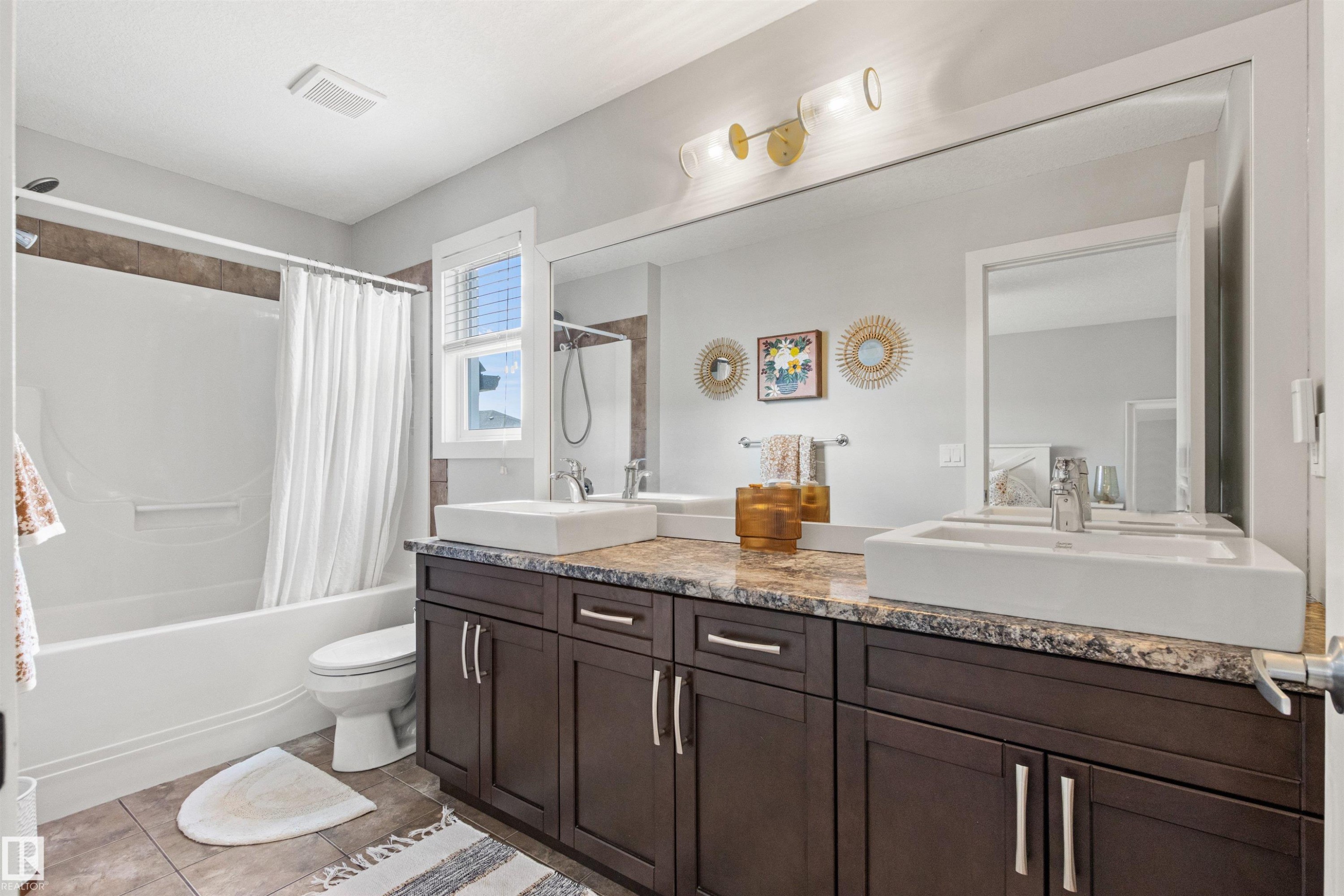 Bathroom featuring a double vanity with dark wood cabinetry, a granite countertop, and two vessel sinks - 38 Hewitt Circle, Spruce Grove, AB - Indoor Photo Showing Bathroom