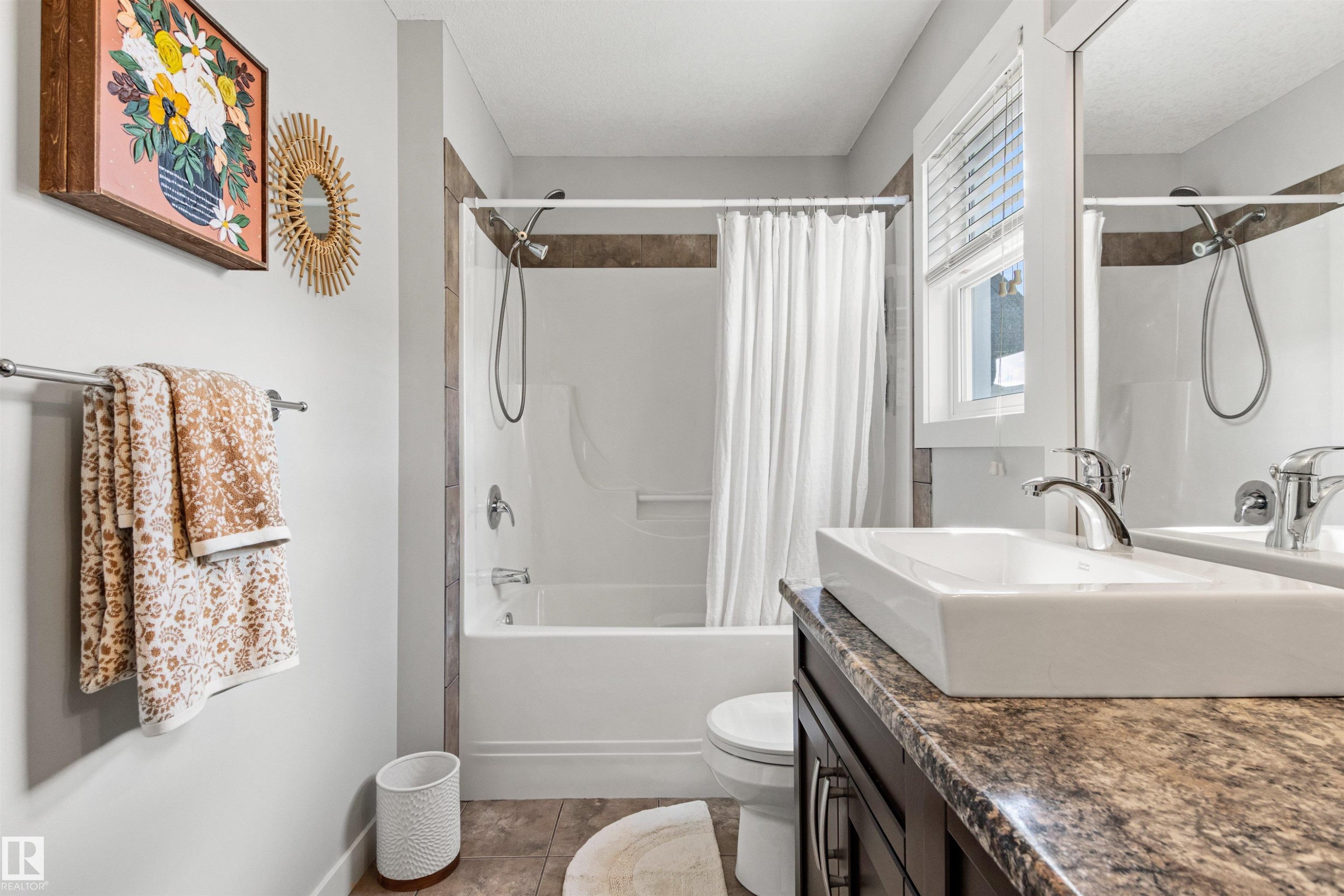 Bathroom featuring a white rectangular vessel sink, a dark wood vanity with a speckled countertop, and a shower-tub combination with a white shower curtain - 38 Hewitt Circle, Spruce Grove, AB - Indoor Photo Showing Bathroom