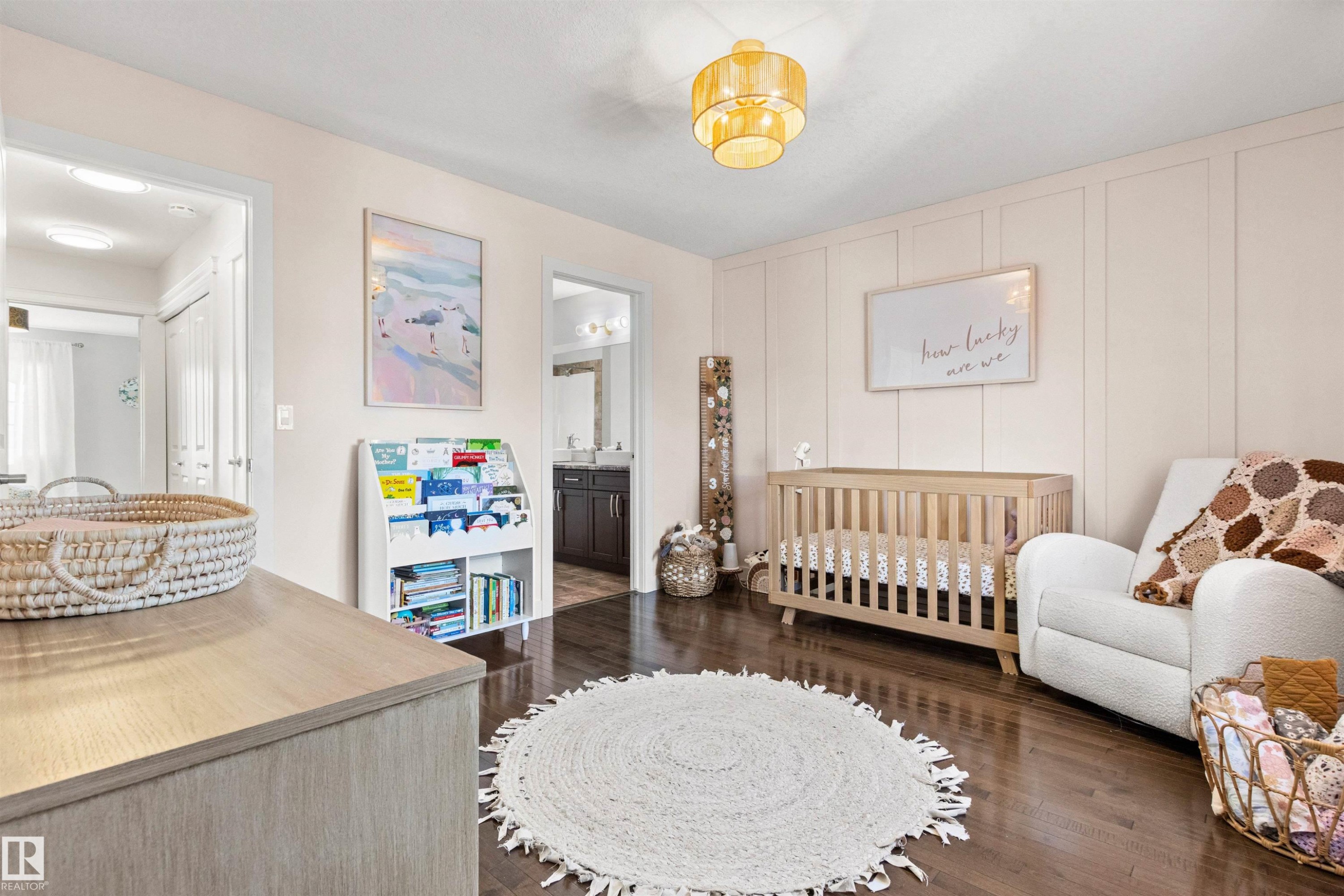 This room features rich hardwood flooring, light-colored walls with paneling detail, and an ornate ceiling light fixture - 38 Hewitt Circle, Spruce Grove, AB - Indoor