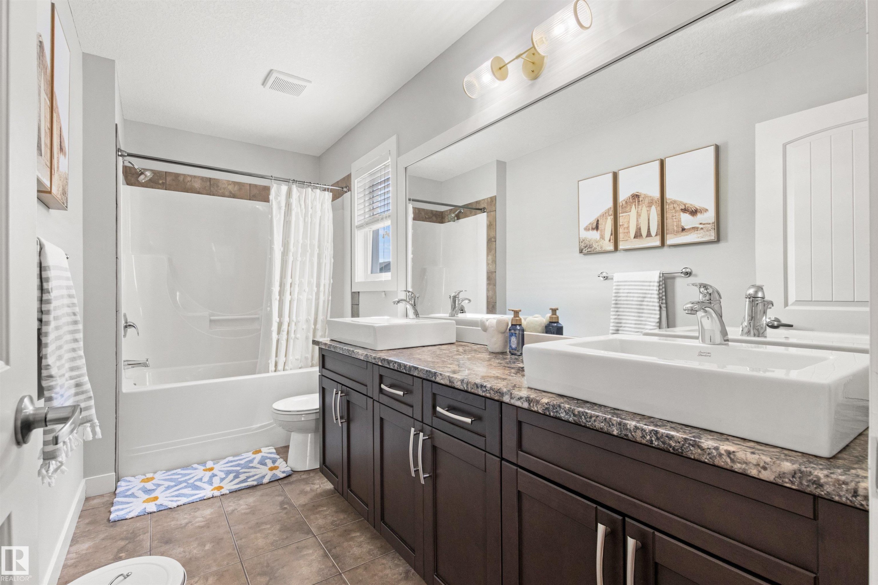 The bathroom features a double vanity with vessel sinks and dark wood cabinetry, a bathtub with a tiled surround, and large wall-mounted mirrors - 38 Hewitt Circle, Spruce Grove, AB - Indoor Photo Showing Bathroom