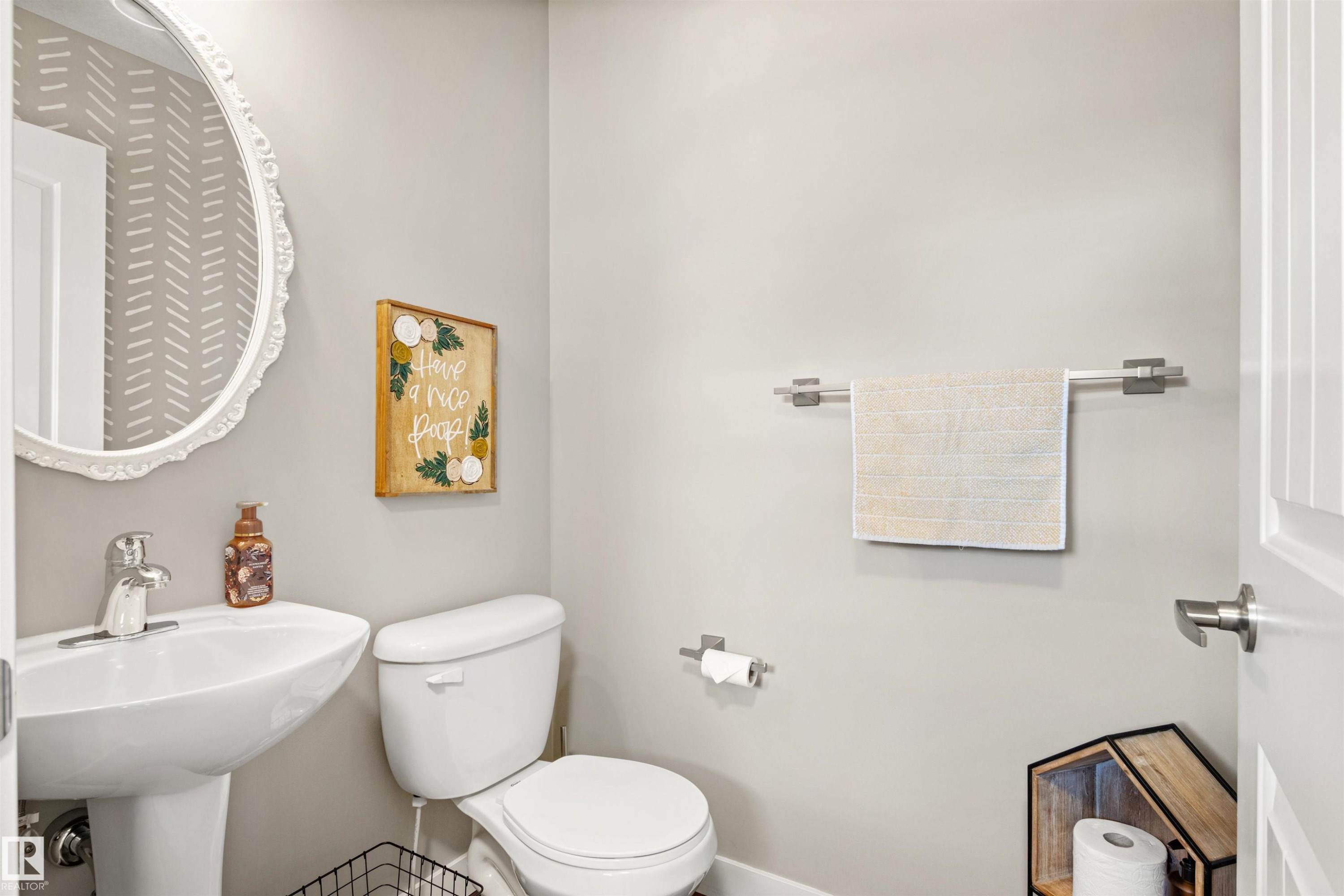 The bathroom features a pedestal sink with a modern faucet, a toilet, and light gray walls - 38 Hewitt Circle, Spruce Grove, AB - Indoor Photo Showing Bathroom