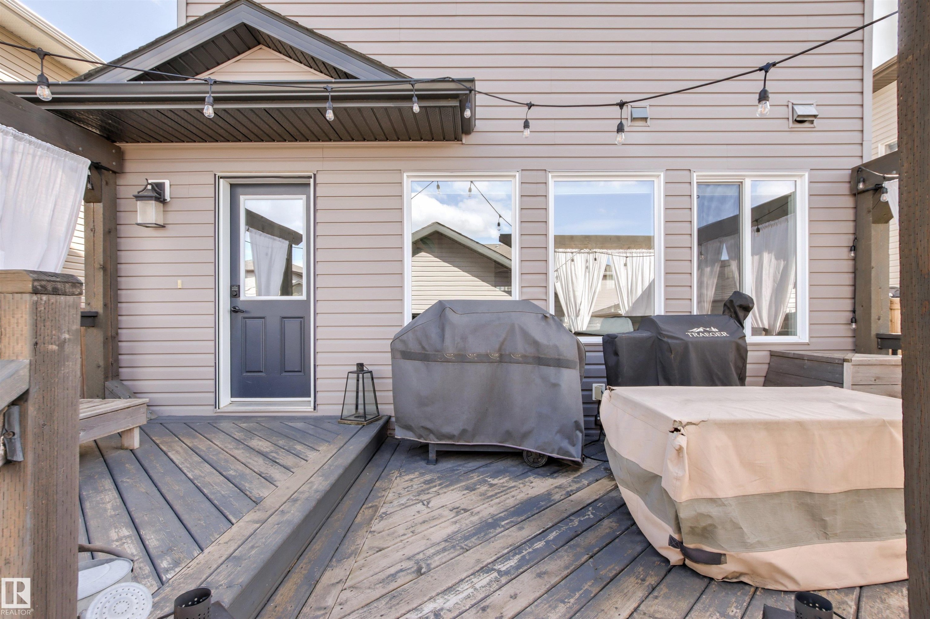 The property features a wooden deck with a ramp, an exterior door with a window, and multiple windows - 38 Hewitt Circle, Spruce Grove, AB - Outdoor With Deck Patio Veranda With Exterior