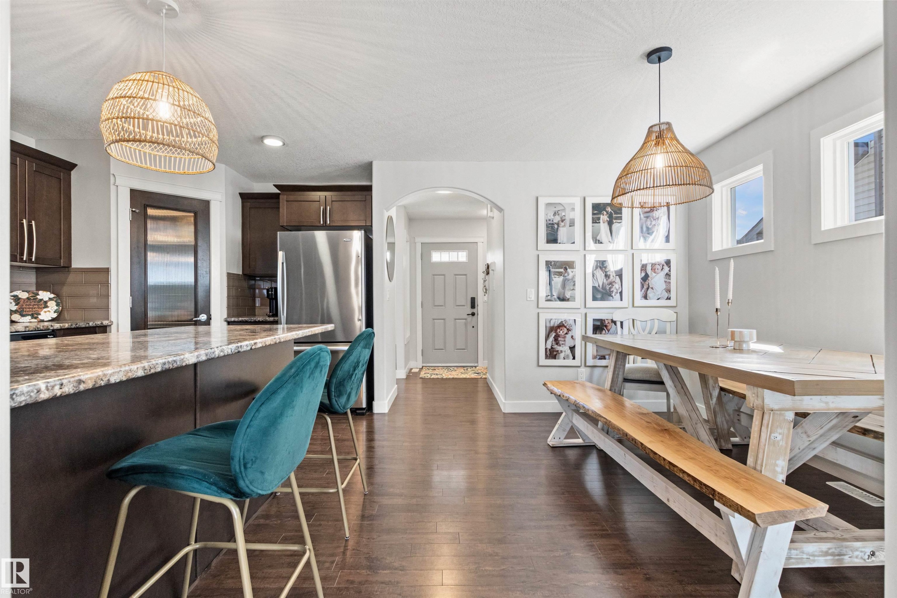 The property features rich hardwood flooring, a spacious kitchen island with a granite countertop, and dark wood cabinetry - 38 Hewitt Circle, Spruce Grove, AB - Indoor