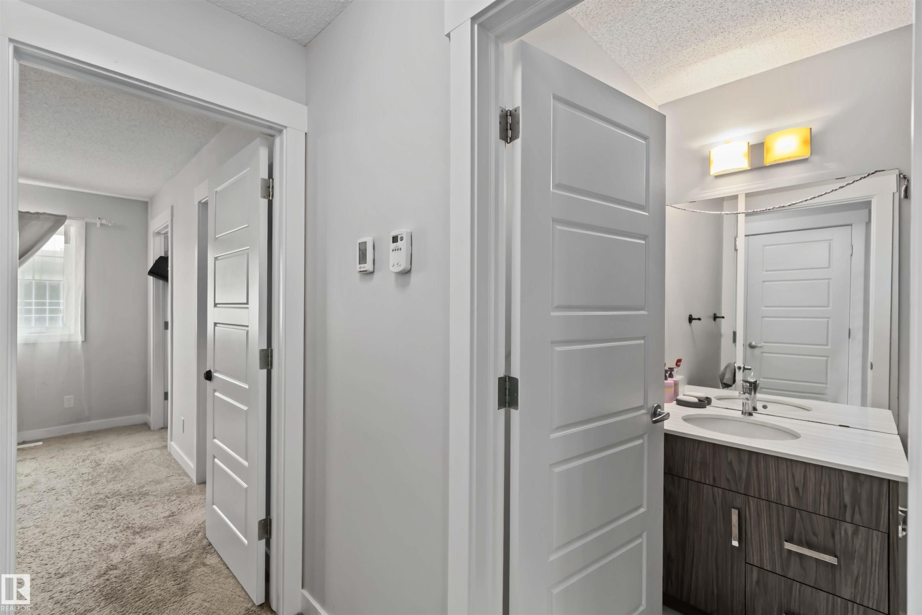Hallway featuring light gray walls and white trim - 2725 Orchards Road, Edmonton, AB - Indoor Photo Showing Other Room
