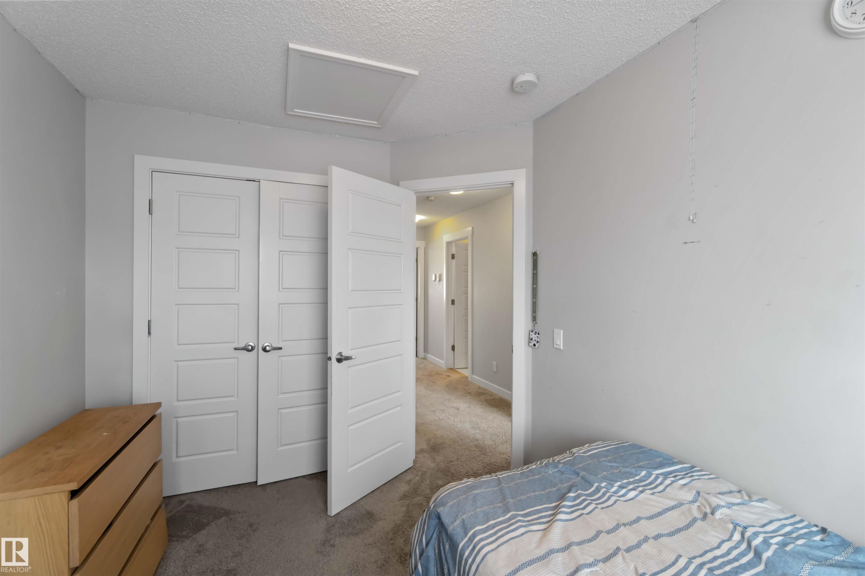 This room features light grey walls and grey carpet flooring - 2725 Orchards Road, Edmonton, AB - Indoor Photo Showing Bedroom