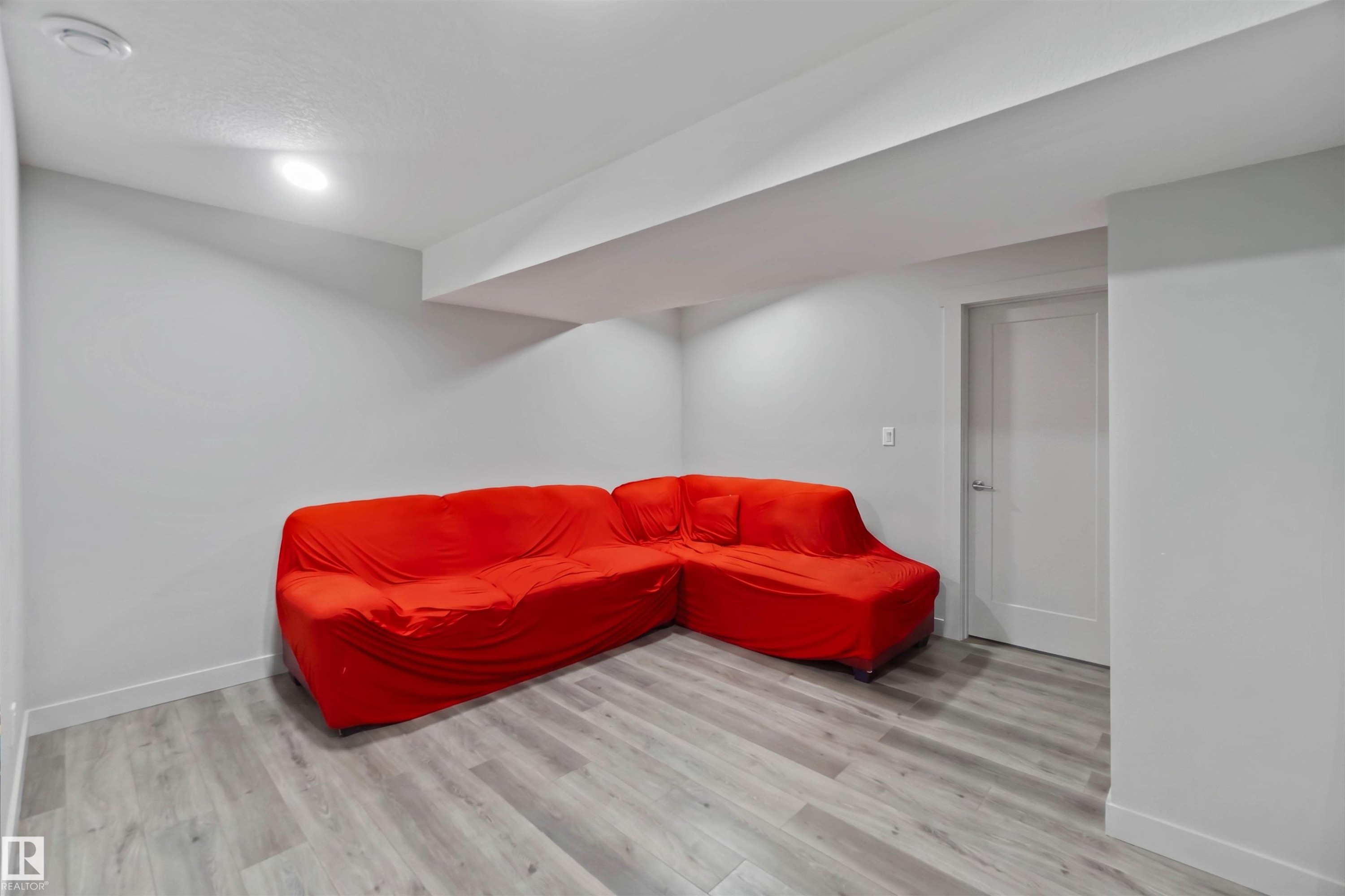 Spacious room with light gray walls, recessed lighting, and wood-look flooring - 2725 Orchards Road, Edmonton, AB - Indoor Photo Showing Other Room