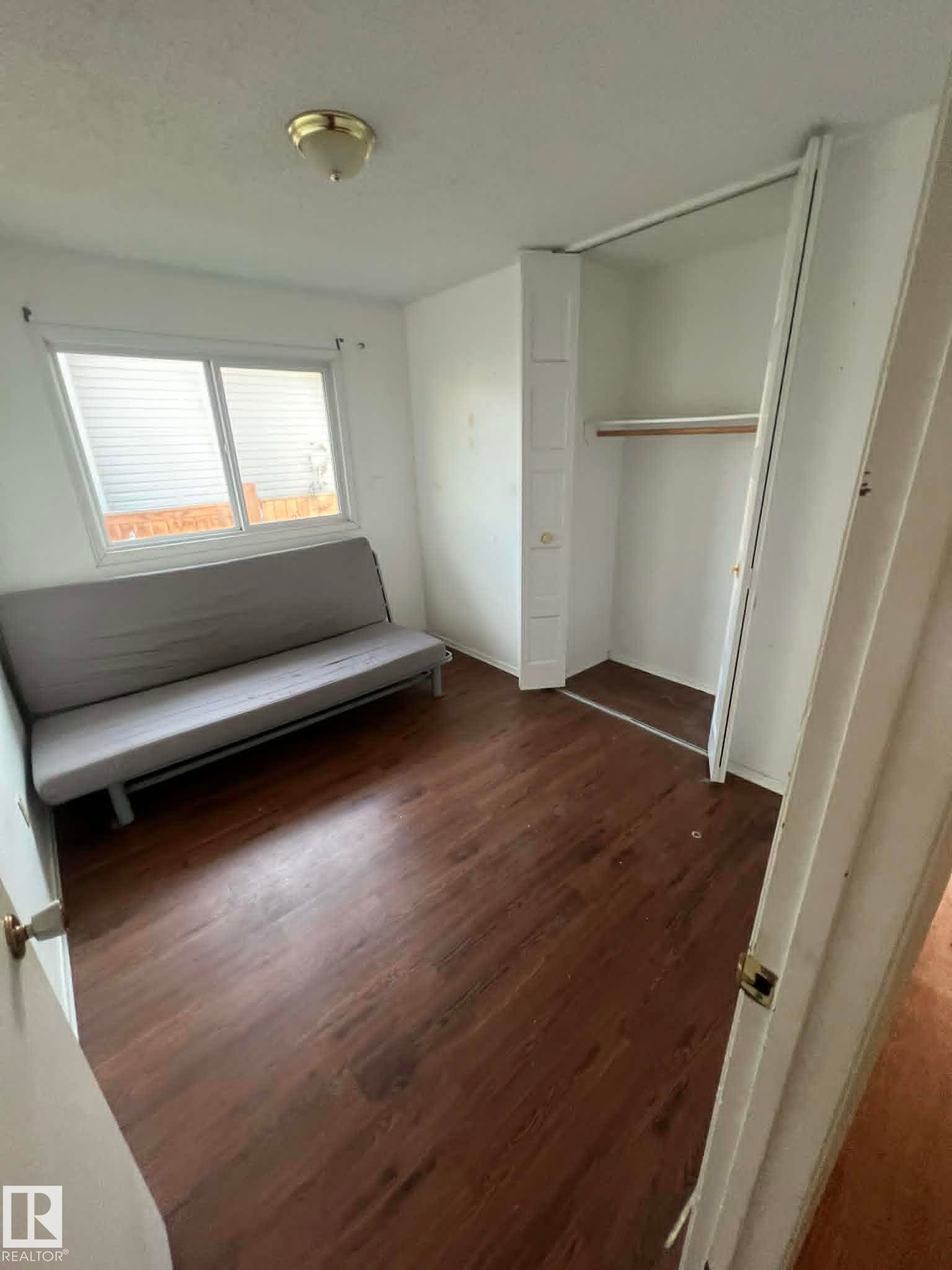 Room featuring wood-finish flooring and a window with blinds - 4129 134A Avenue Nw, Edmonton, AB - Indoor