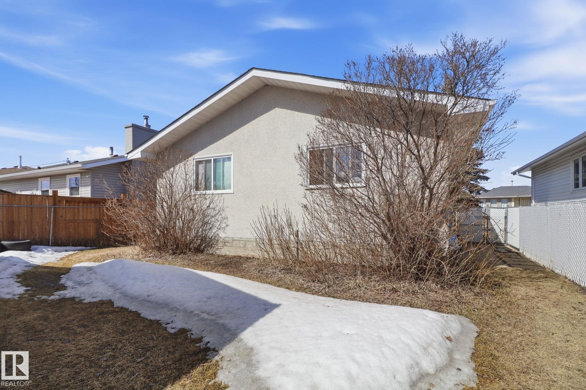 The property features a stucco exterior, a sloped roof, and a chimney - 4129 134A Avenue Nw, Edmonton, AB - Outdoor