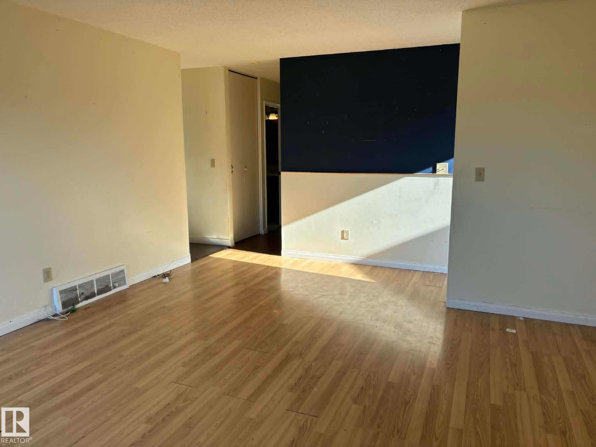 Open concept space featuring wood-finish flooring - 4129 134A Avenue Nw, Edmonton, AB - Indoor Photo Showing Other Room