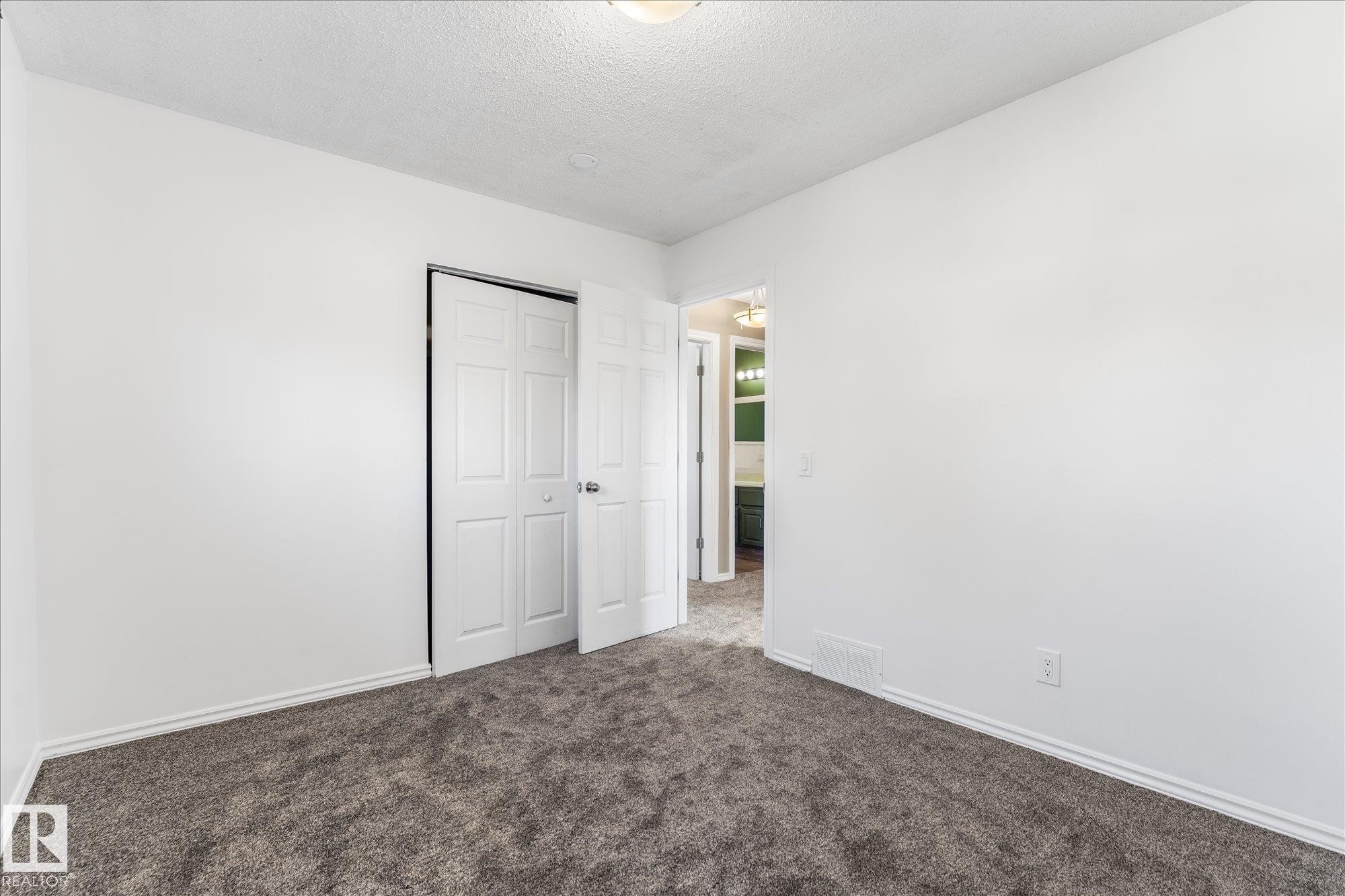 This room features white walls, dark grey carpeting, and white baseboards - 2626 49 Street, Edmonton, AB - Indoor Photo Showing Other Room