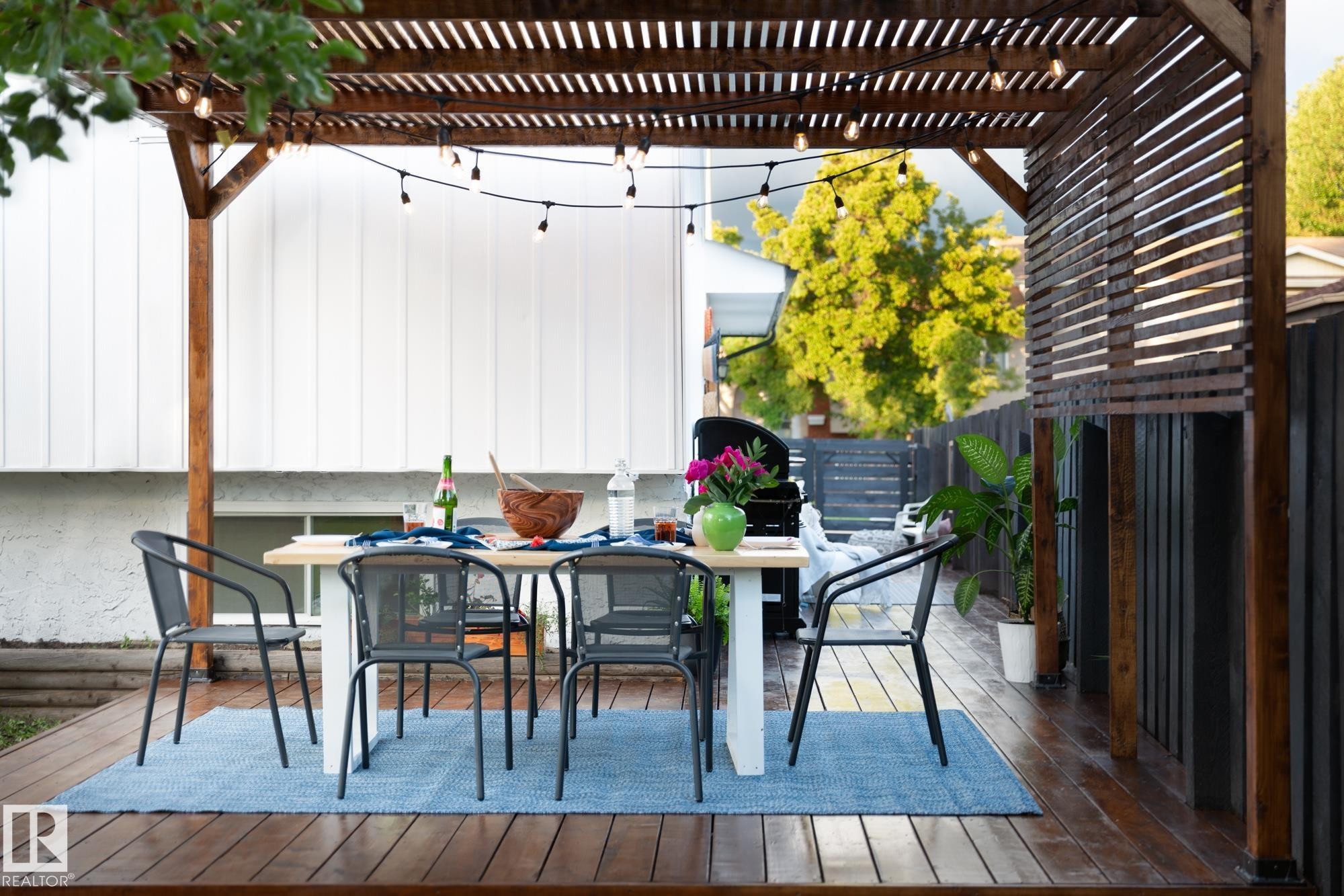 The property features an outdoor deck with a slatted wooden pergola, providing a designated area for outdoor leisure - 2626 49 Street, Edmonton, AB - Outdoor With Deck Patio Veranda With Exterior