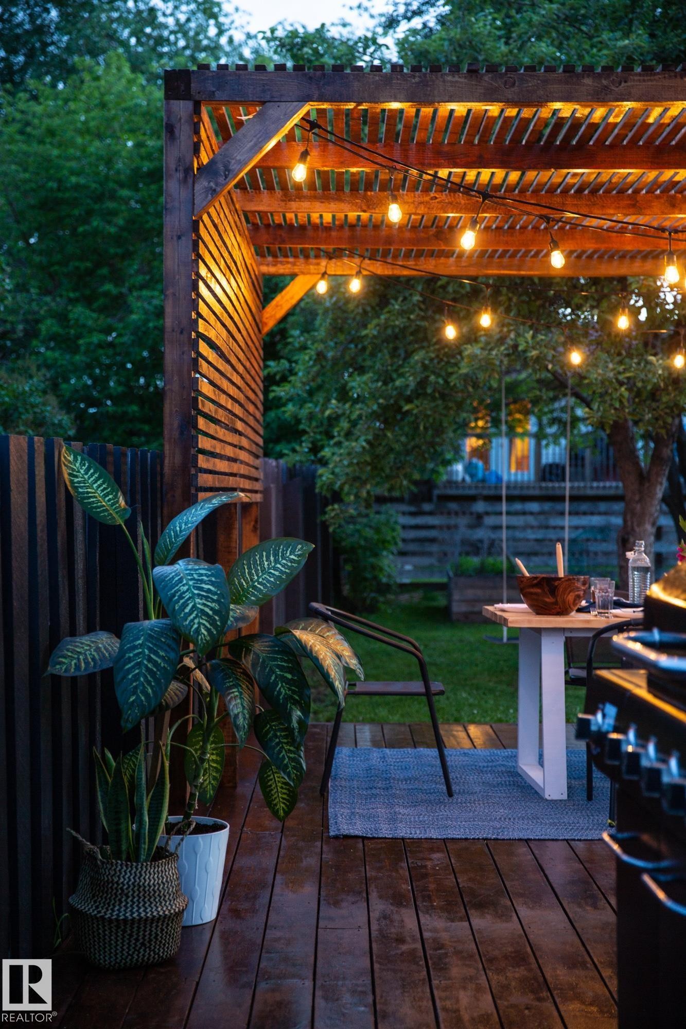 This outdoor space features a wooden pergola adorned with string lights, providing an inviting ambiance - 2626 49 Street, Edmonton, AB - Outdoor With Deck Patio Veranda