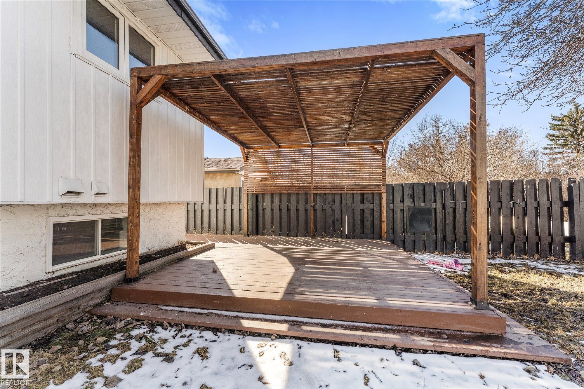 The property features an extensive deck with a wooden pergola, offering an inviting outdoor space - 2626 49 Street, Edmonton, AB - Outdoor With Exterior