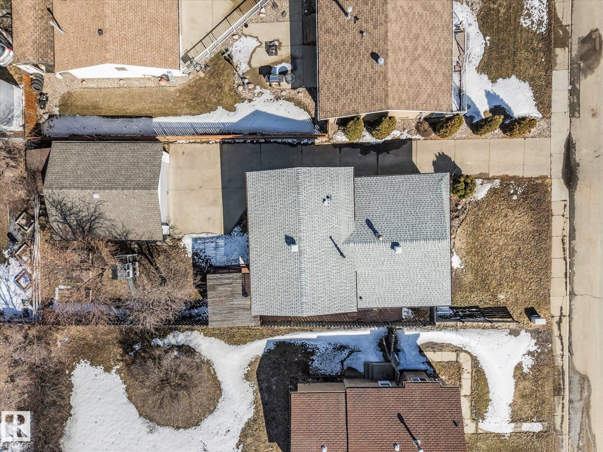 Aerial view of the property, showcasing a gray-shingled roof, a paved driveway, and surrounding grounds with natural landscaping - 2626 49 Street, Edmonton, AB - Outdoor With Deck Patio Veranda