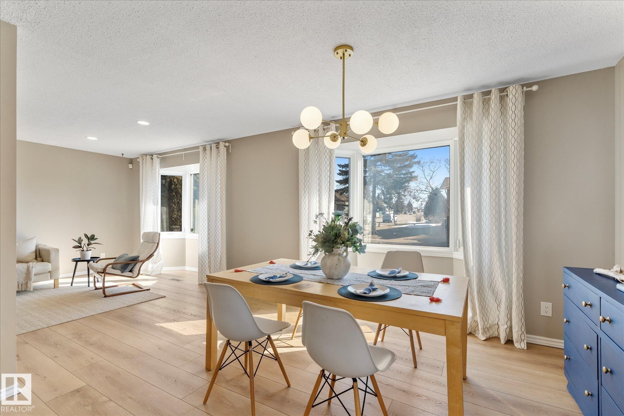 The living and dining area features light-toned flooring, large windows with drapes, and recessed lighting - 2626 49 Street, Edmonton, AB - Indoor Photo Showing Dining Room