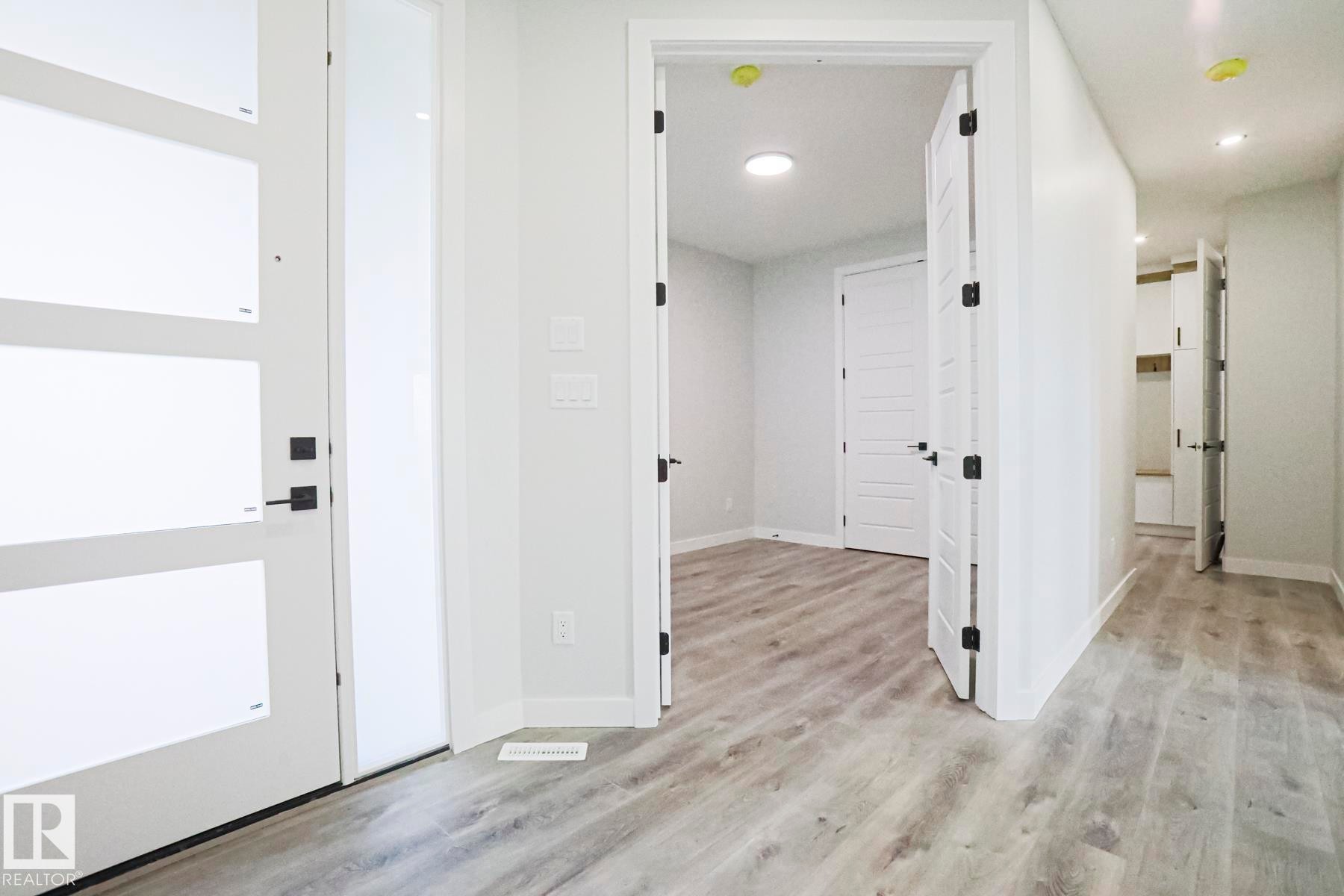 This space features light-colored plank flooring and white walls, creating a bright and airy atmosphere - Rural Leduc County, AB - Indoor Photo Showing Other Room