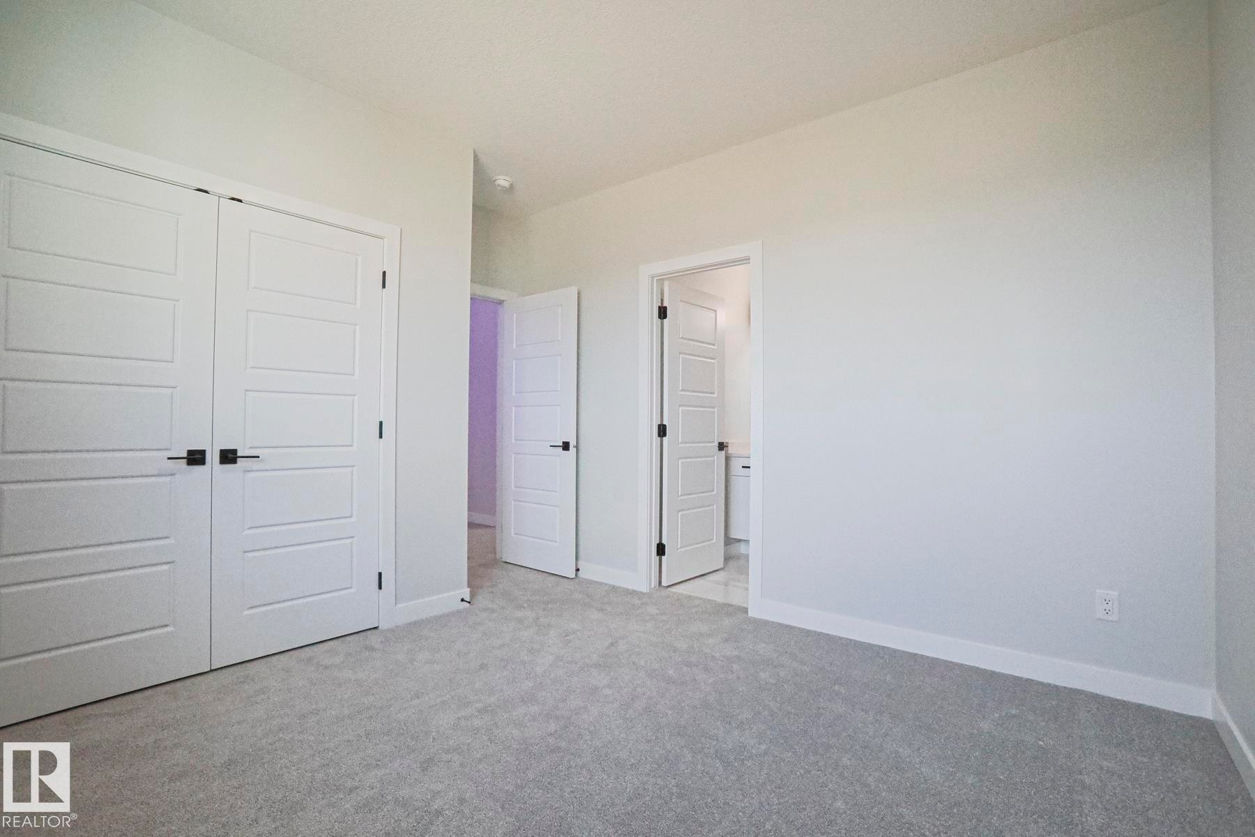The room features light gray carpeting, white walls, and white trim - Rural Leduc County, AB - Indoor Photo Showing Other Room